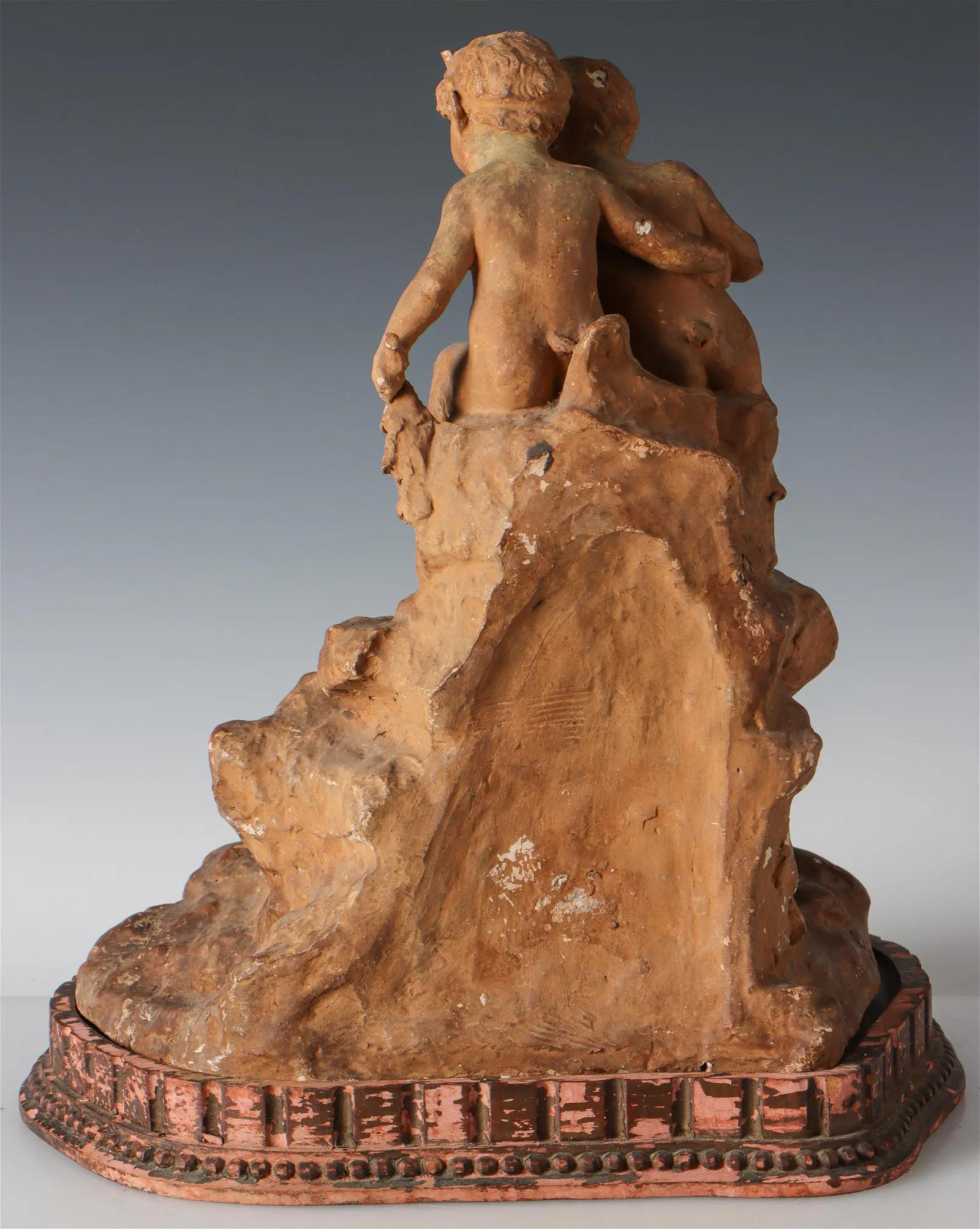 A charming figural group of Fauns sitting above a waterfall, in cast stucco with terracotta painted finish, all on a custom wood base. Mid 19th Century. Base bears an old label from Victor Carl Antiques.