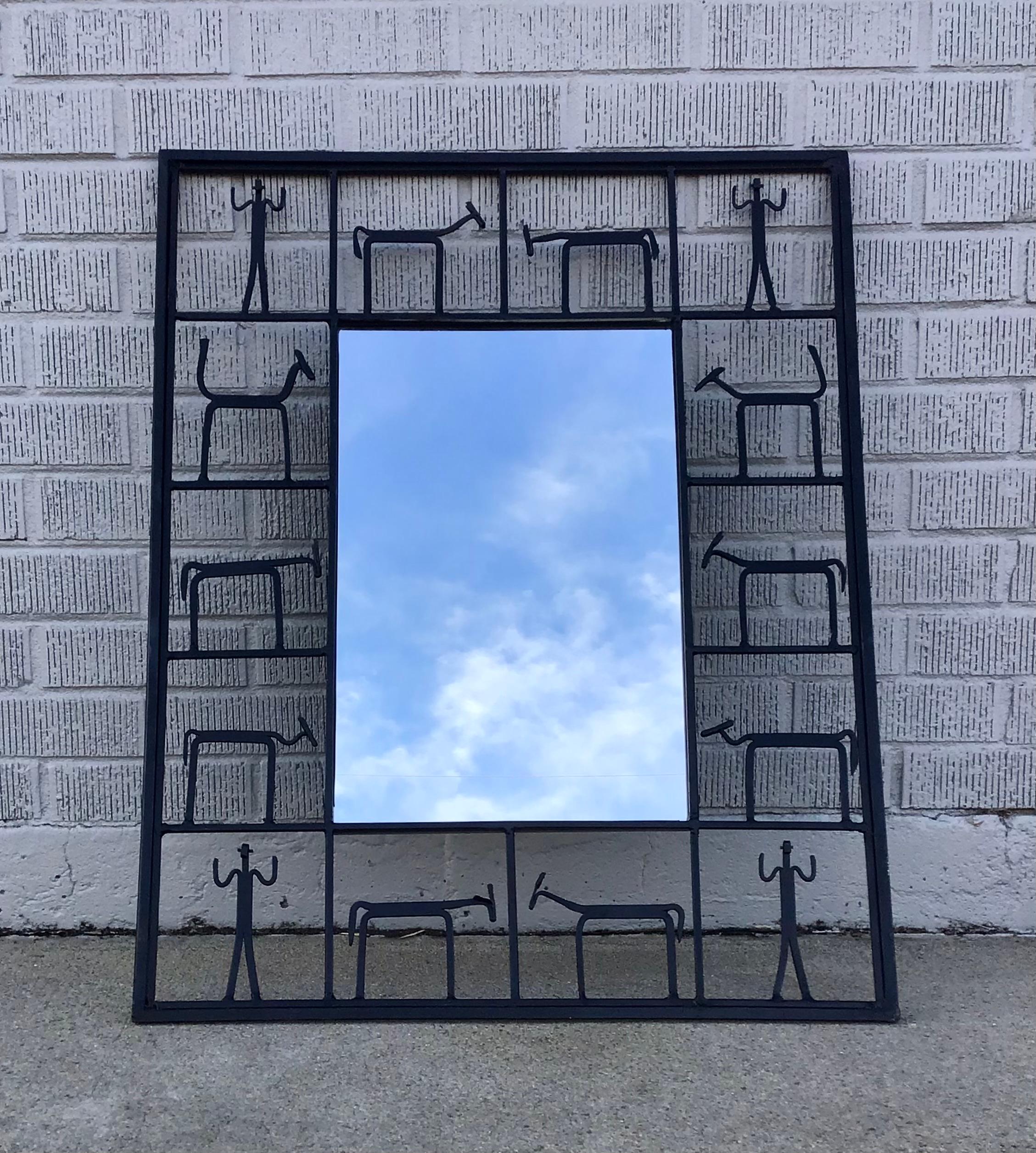 Modernist wall mirror attributed to Frederick Weinberg. This rectangular mirror features a black iron frame depicting animals and figures.

Measurements: 24.25