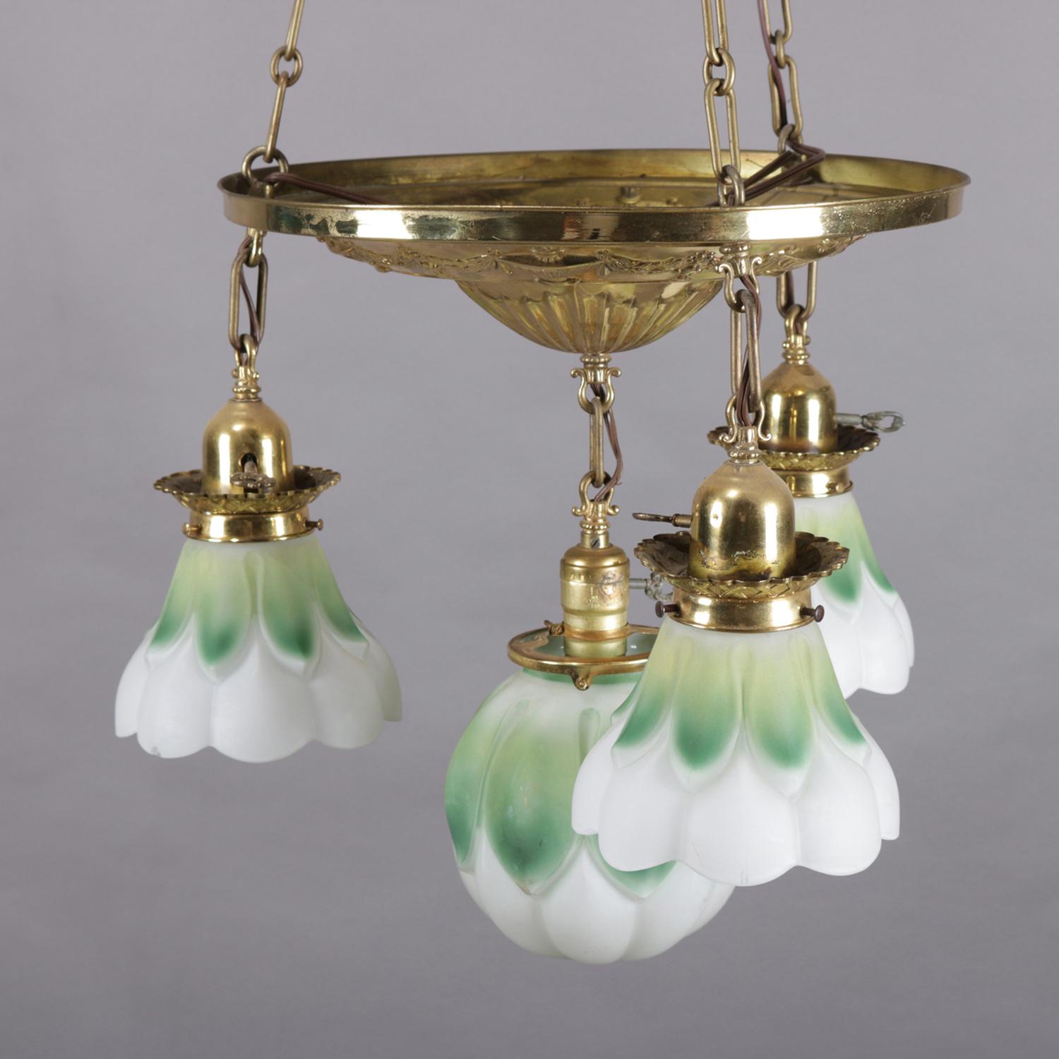 Figural neoclassical chandelier features brass base with embossed urn and garland decoration and four drop lights with floral form frosted and painted glass shades, circa 1930.

Measures: 45