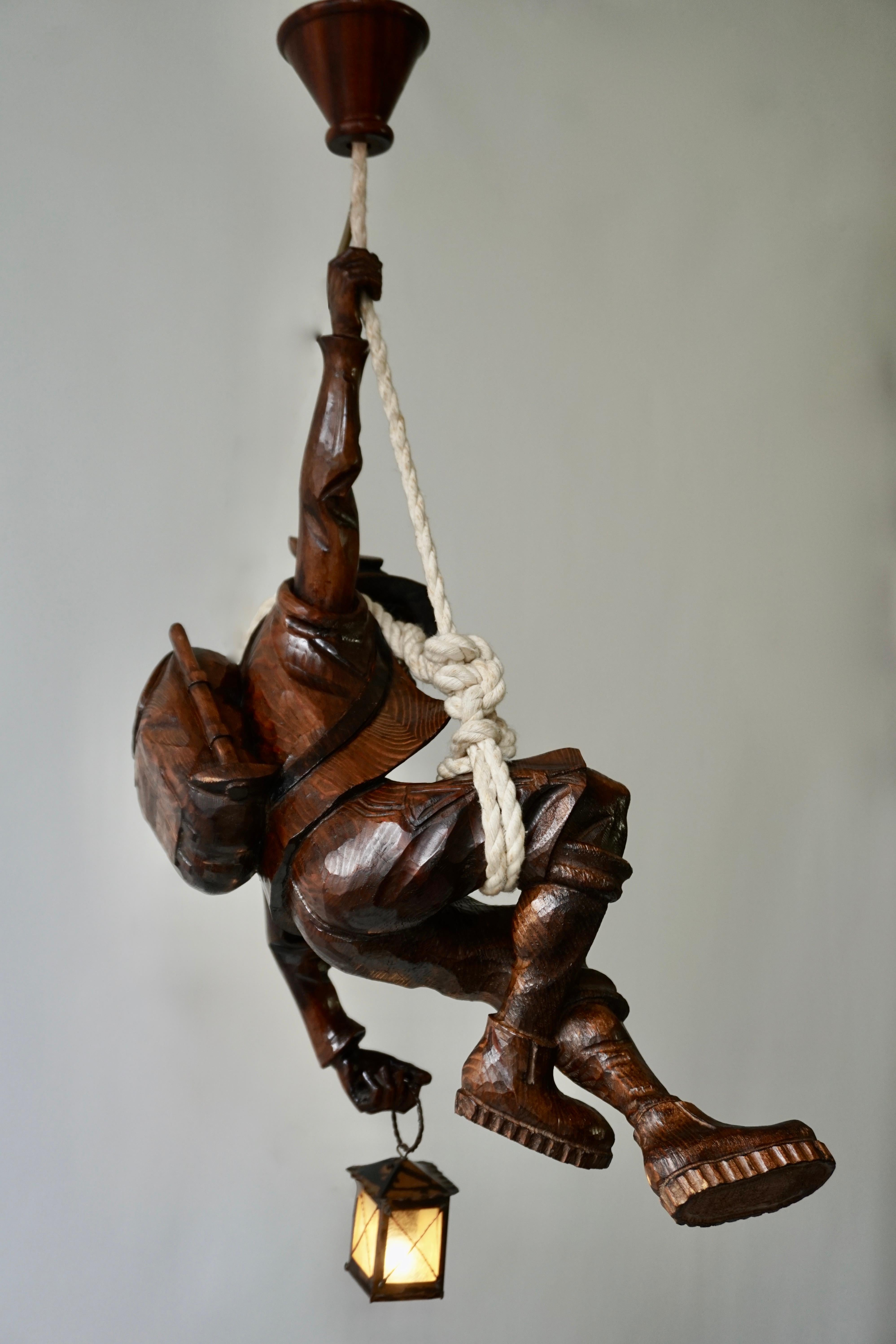 Stunning very rare hand carved Black Forest style wood mountain climber lantern or ceiling light. Pendant lamp off a mountain climber hanging from a rope with a lantern in his hand.
The light requires one single E14 screw fit lightbulb (40Watt