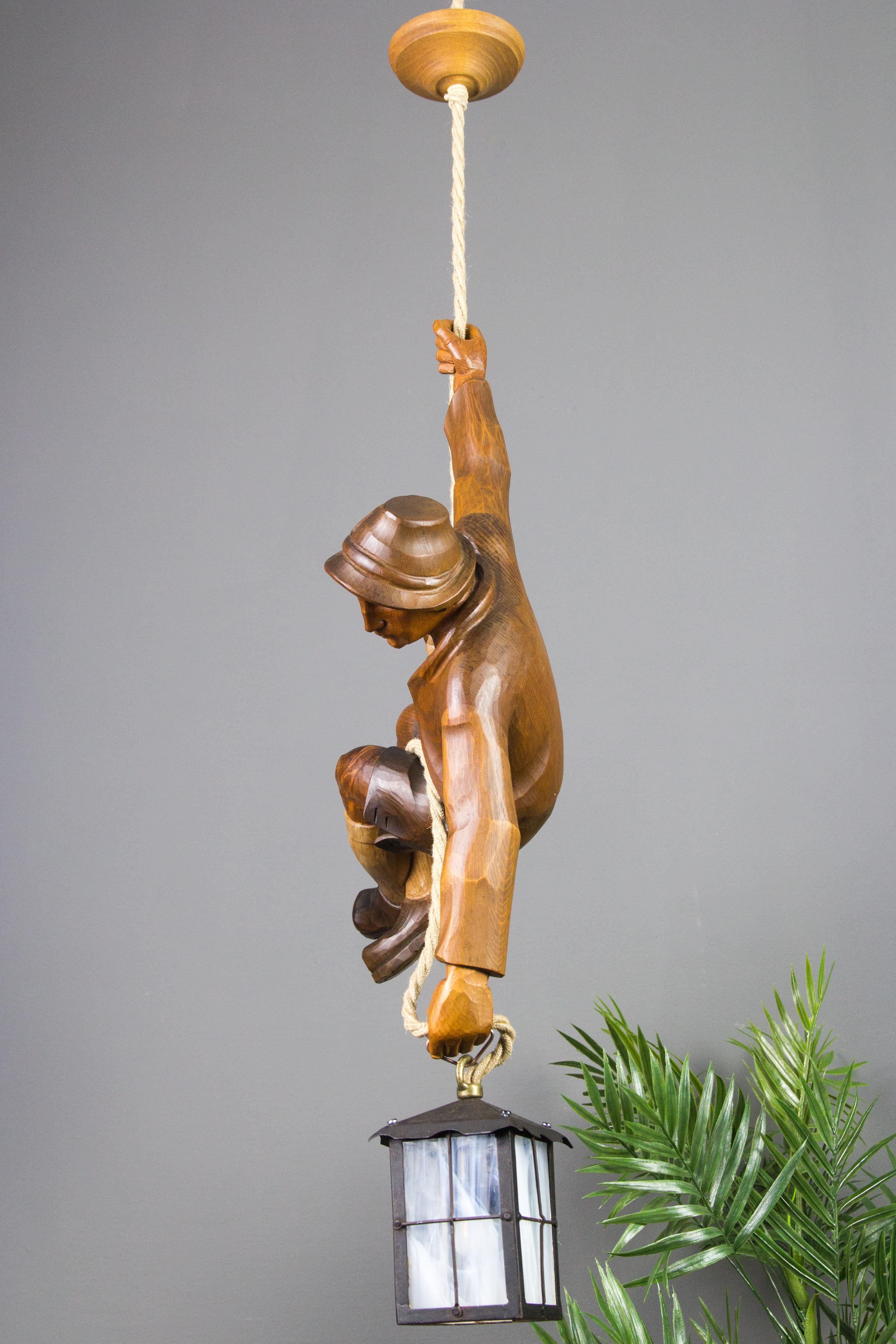 Metal Figural Pendant Light of a Hand Carved Wood Figure Mountain Climber with Lantern
