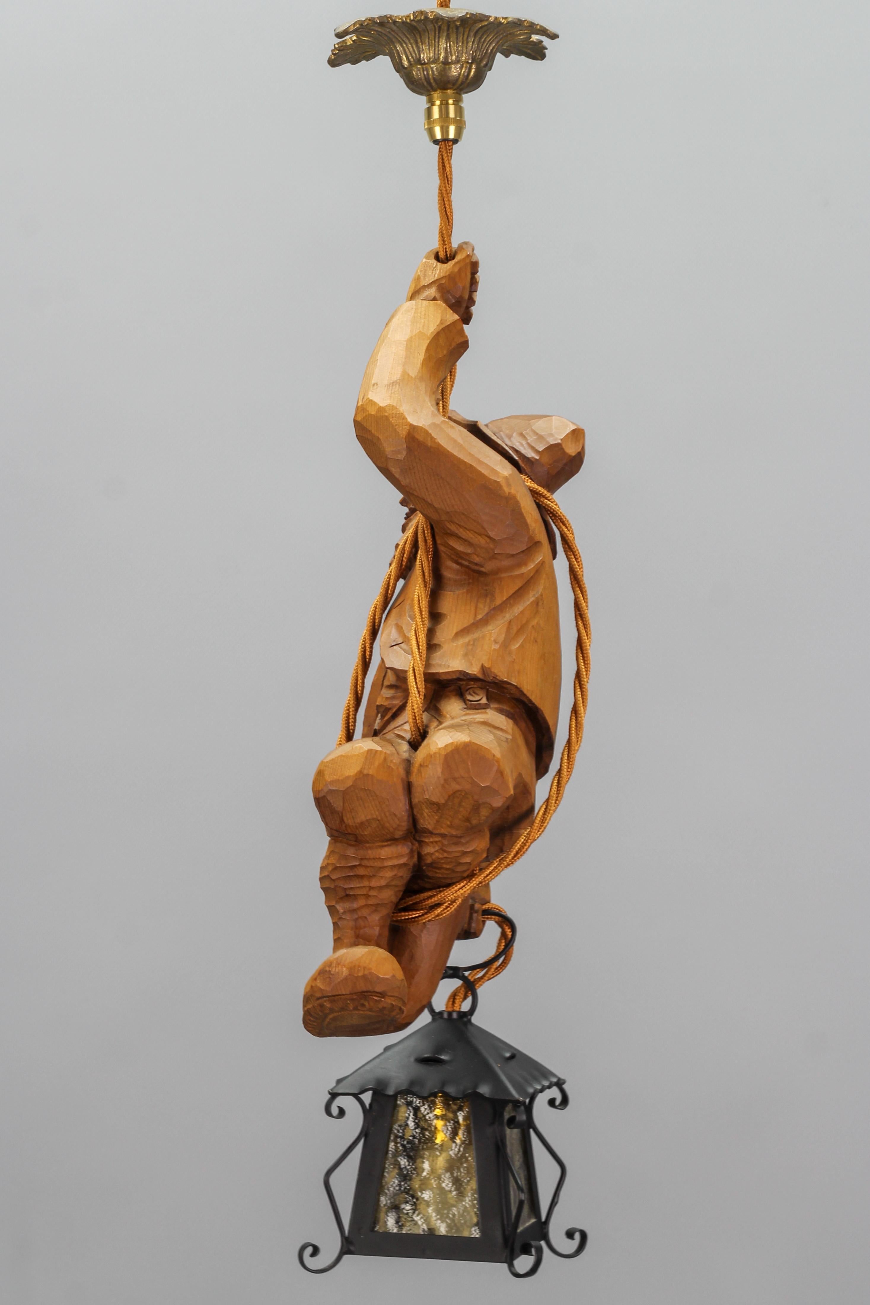 Sculpté à la main Lampe à suspension figurative avec une figure de grimpante de montagne sculptée et une lanterne, Allemagne en vente
