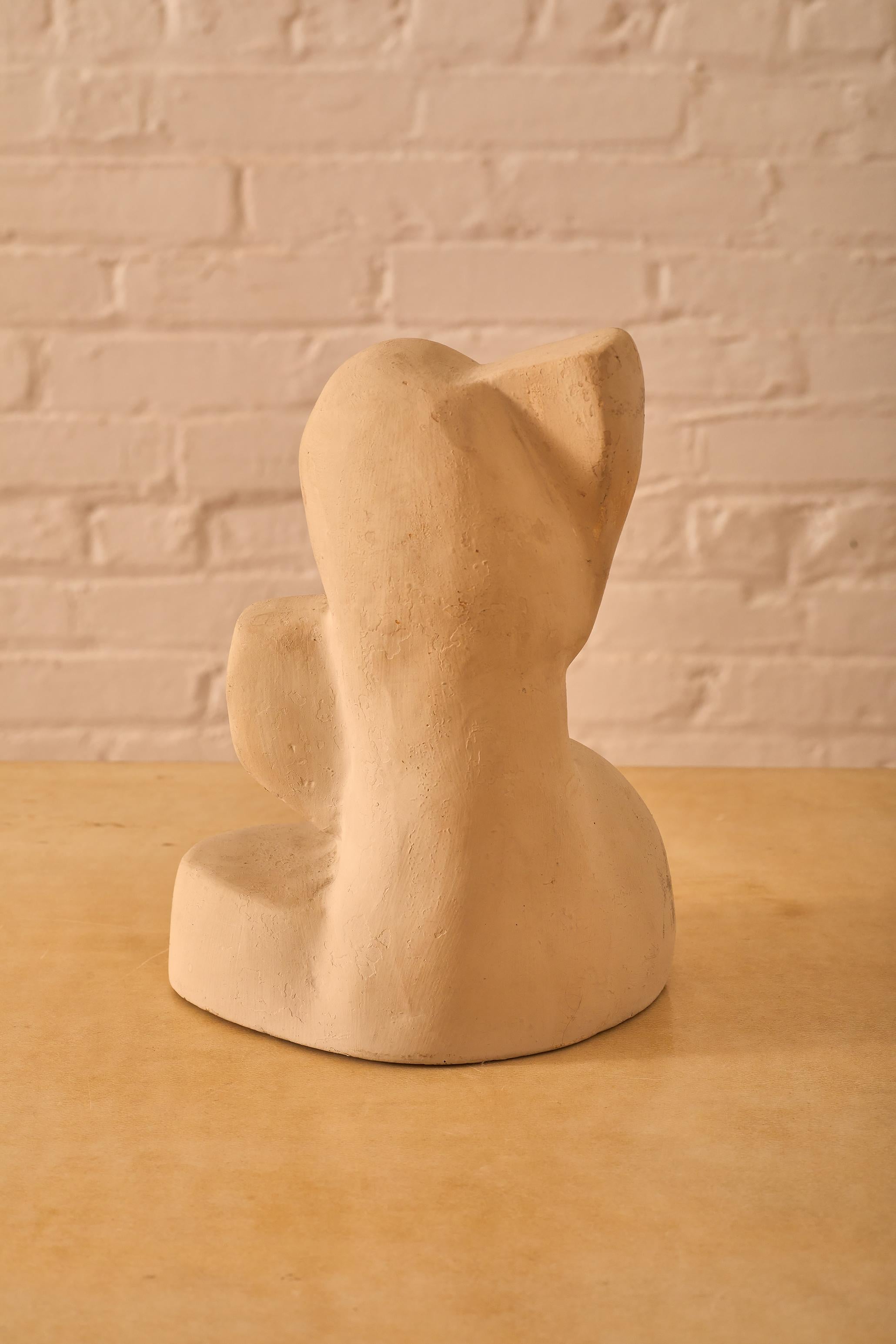 Figurative abstract sculpture in plaster depicting a seated man.