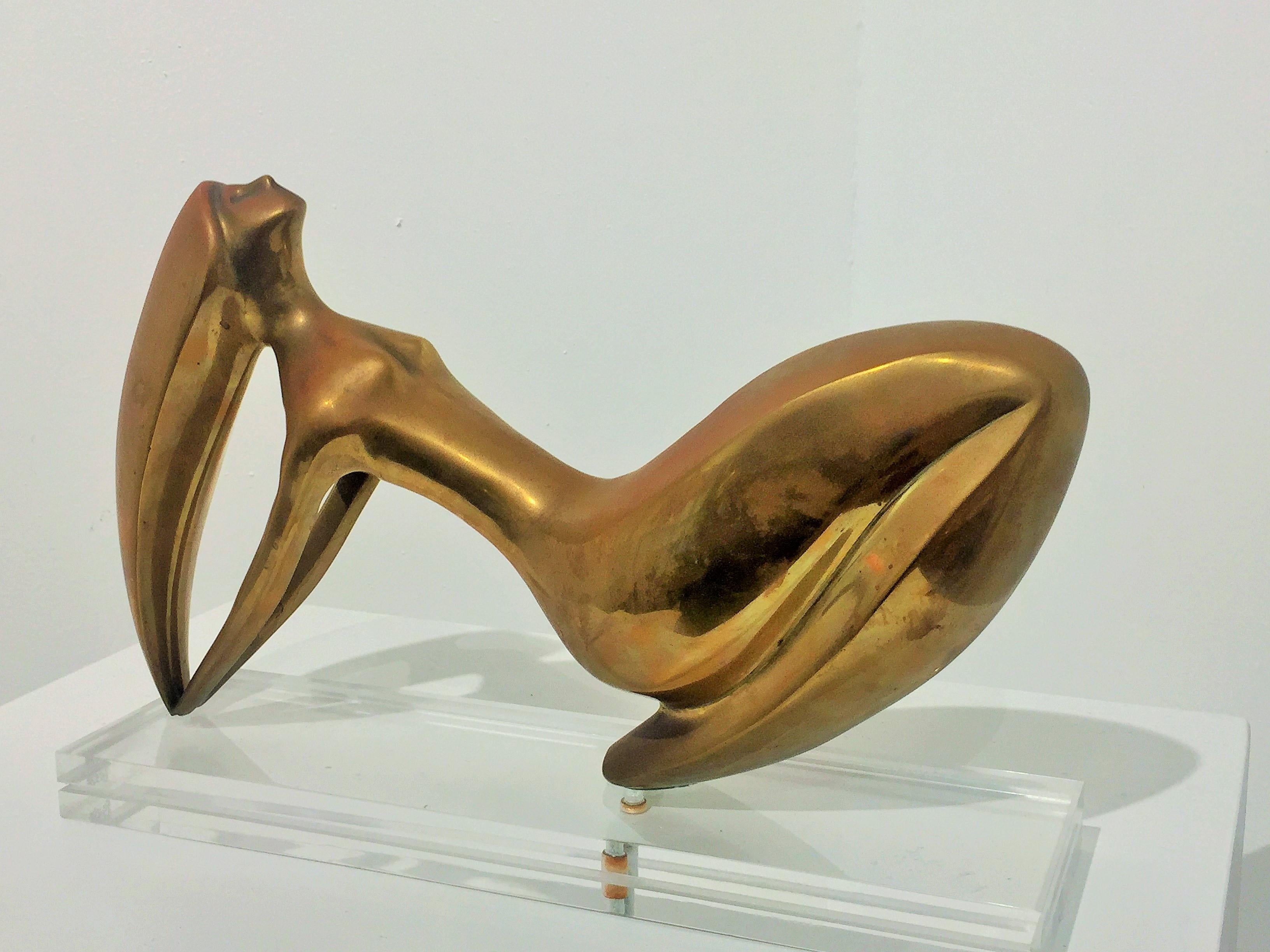 Figurative reclining female brass sculpture, with acrylic base. She has a beautiful patina and her hair is an acrobatic marvel that takes center stage. The acrylic base allows the sculpture to be viewed as in mid-air, circa 1970s.
 