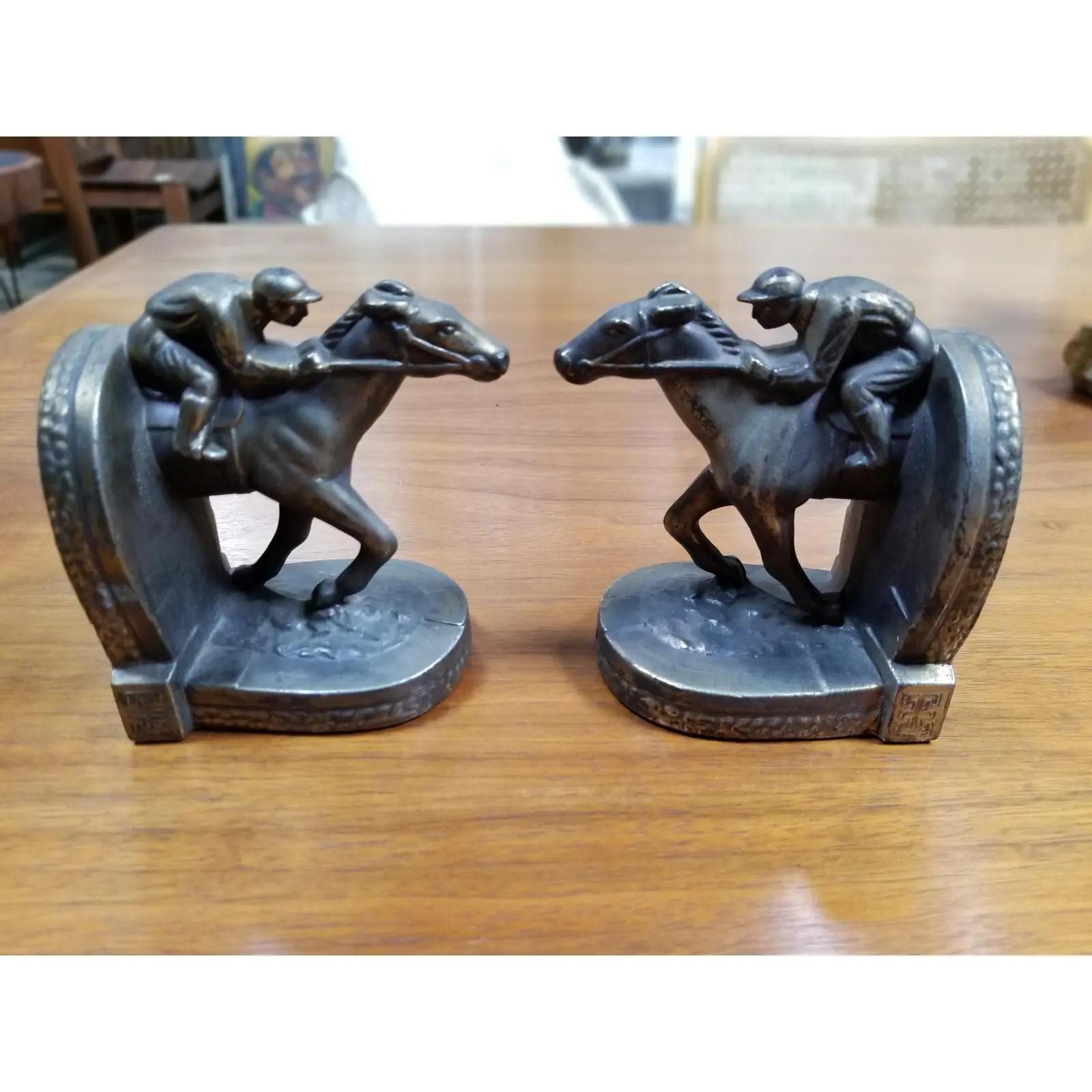 A pair of figurative horse jockey race, track metal bookends by BPM, dated 1950. Jockey riding in horse race. Original condition with original finish. Measurements are for each bookend.