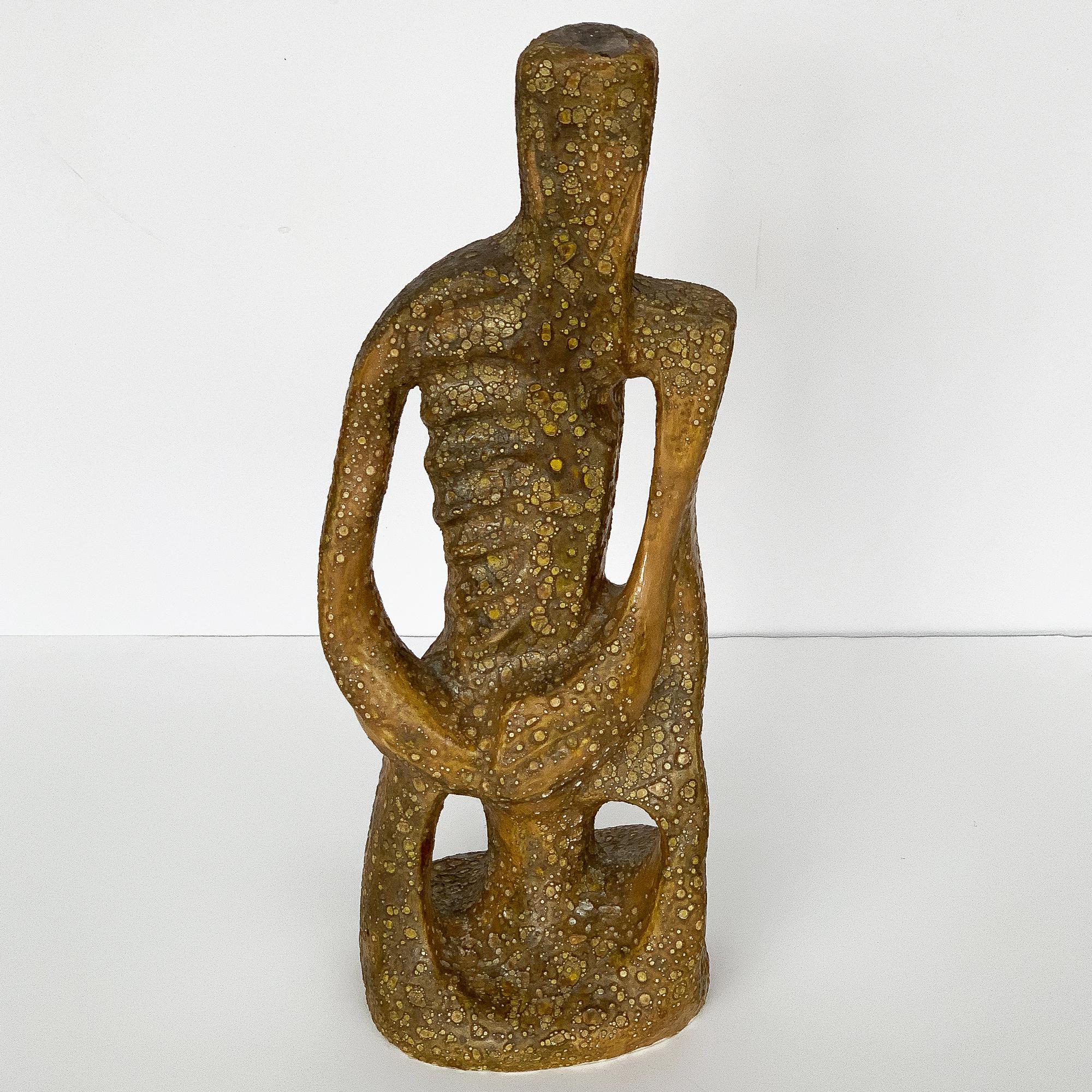 A figurative male abstract ceramic sculpture with a highly textured lava glaze. Glaze is an ocre and light brown color. Signed and dated 1961. Unknown artist and signature possibly reading 