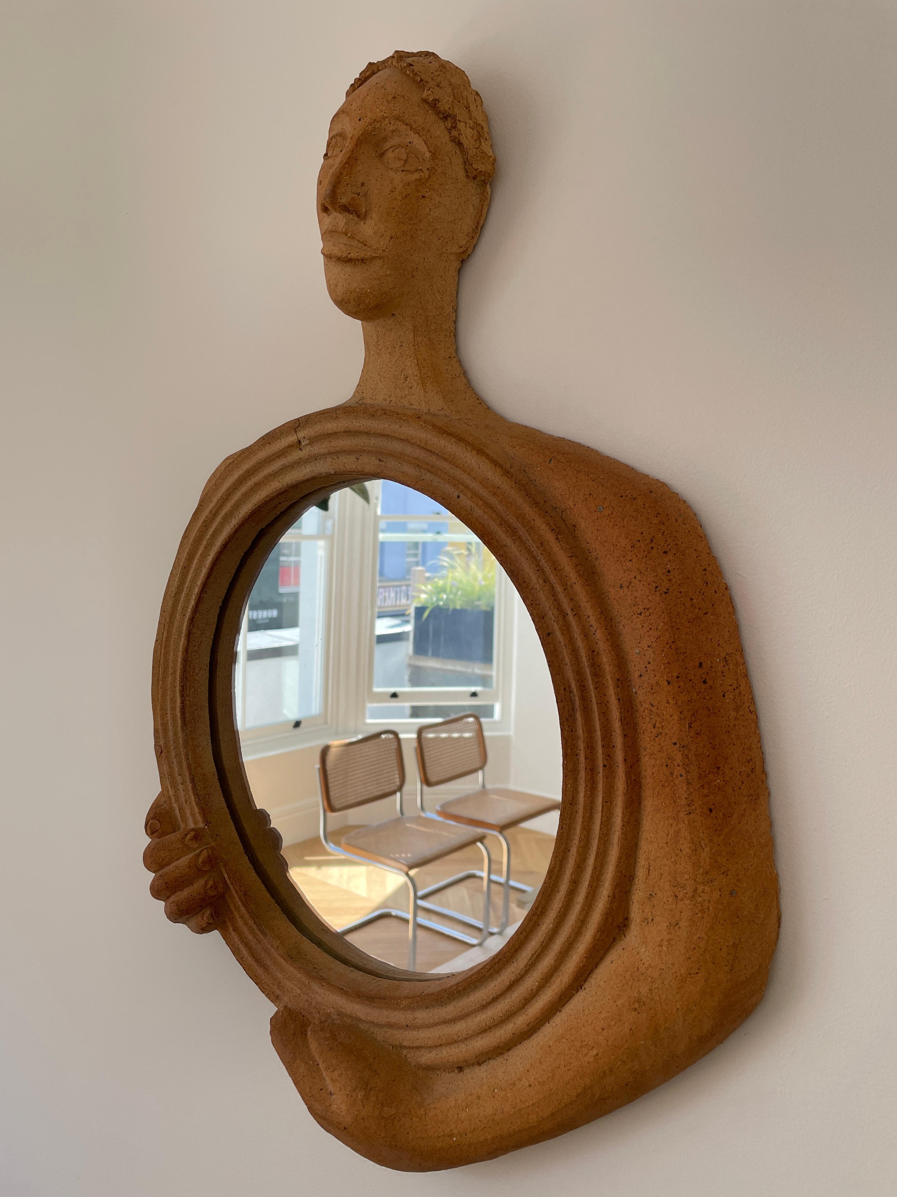 Height: 57cm
Width: 42cm
Depth: 9cm

Designer: Gabriel Sébastien Simonet
Date: 1950s
Materials: Chamotte clay, glass

Description: This beautifully inviting mirror is formed figure gently holding the mirror glass. It has the wonderful feature of