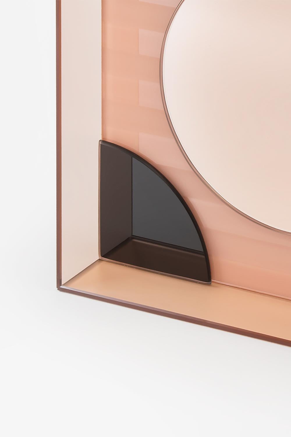 This wall or table mirror juxtaposes opaque, shiny and colored reflective glass in an artistic arrangement to create an unconventional and striking accessory that is as much a work of art as a mirror.