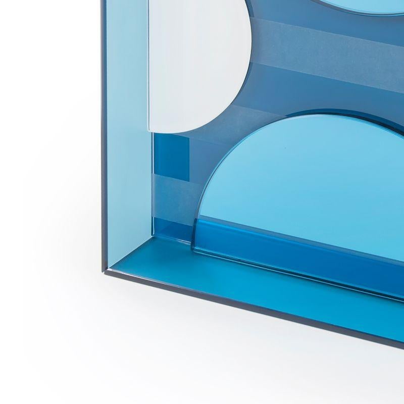 This mirror for wall or tabletop juxtaposes matte, glossy and coloured reflective glass in an artful arrangement to create an unconventional, striking accessory that is as much a work of art as a mirror.

