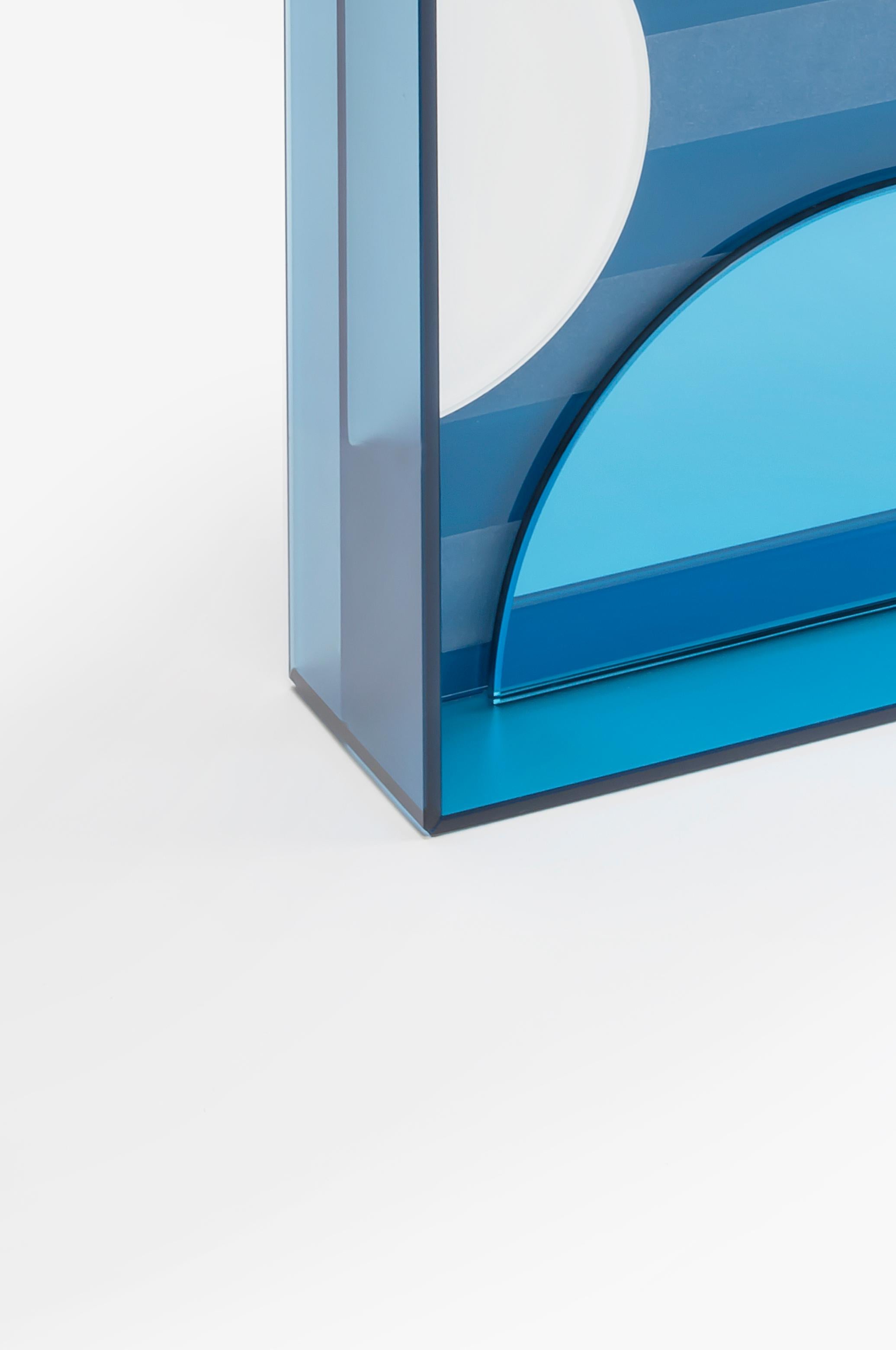 This mirror for wall or tabletop juxtaposes matte, glossy and coloured reflective glass in an artful arrangement to create an unconventional, striking accessory that is as much a work of art as a mirror.

