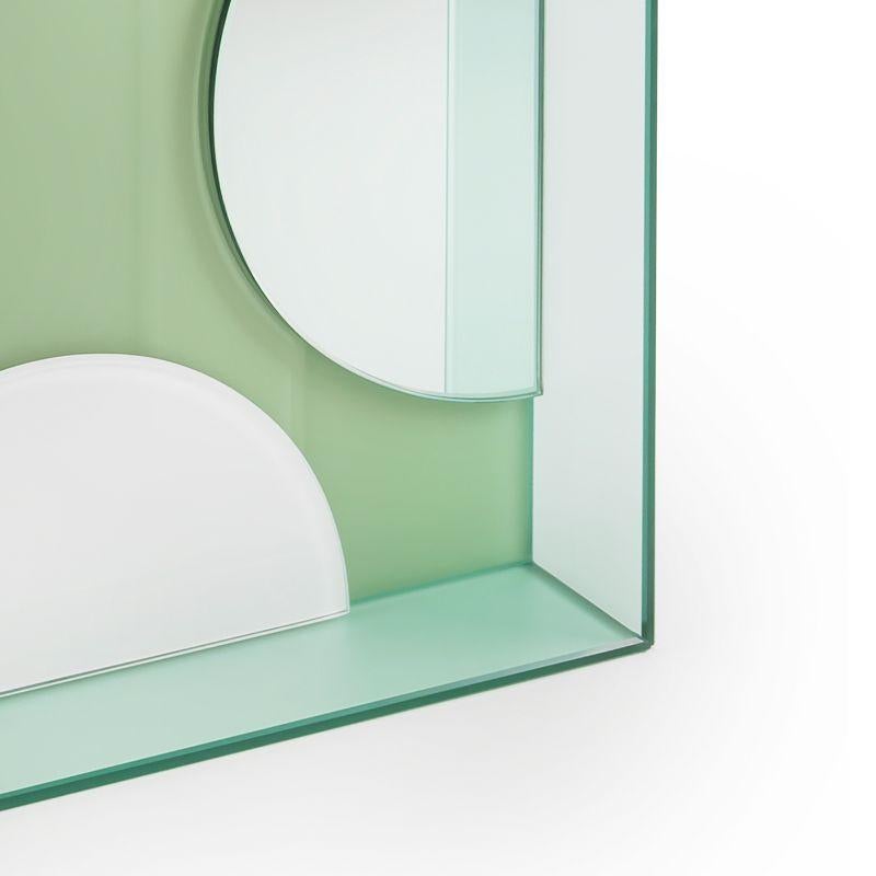 This mirror for wall or tabletop juxtaposes matte, glossy and coloured reflective glass in an artful arrangement to create an unconventional, striking accessory that is as much a work of art as a mirror.
