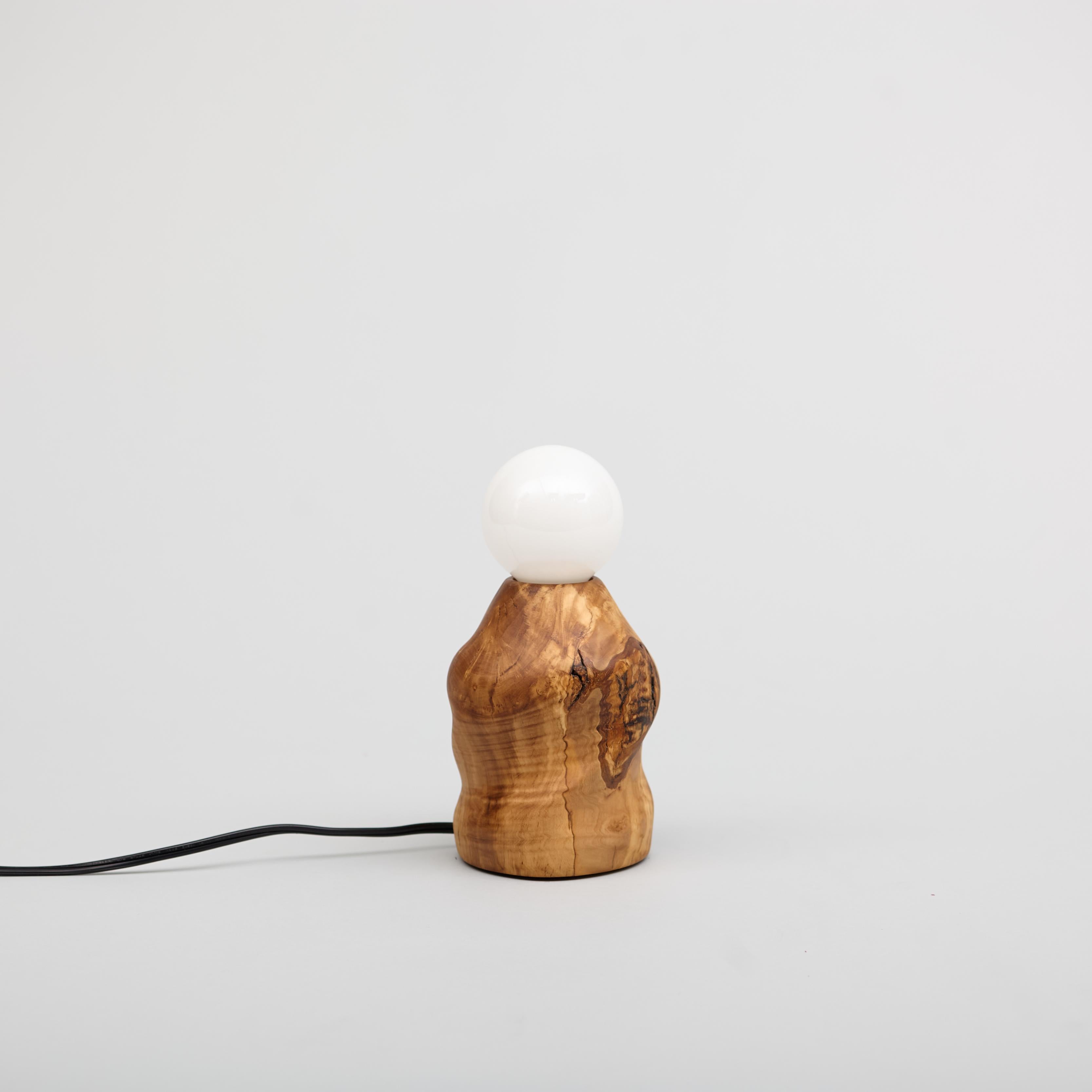 Lámpara de madera de olivo tallada a mano en el torno mediante una técnica que requiere mucho tiempo llamada torneado multieje. Incluye una bombilla LED y un regulador de intensidad en línea. La madera de olivo procede de un árbol caído en Canyon