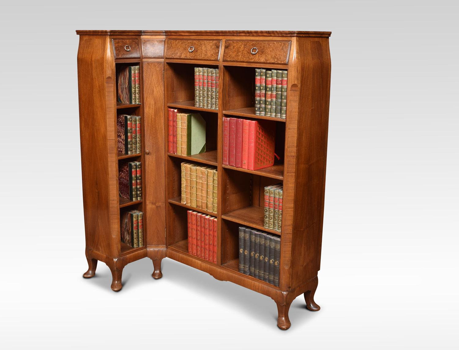 Figured walnut corner bookcase by Whytock & Reid. The lipped top over three burr walnut drawers. To the adjustable shelves surrounding a slim corner cupboard. Raised on shaped apron and squat cabriole legs terminating in pointed pad