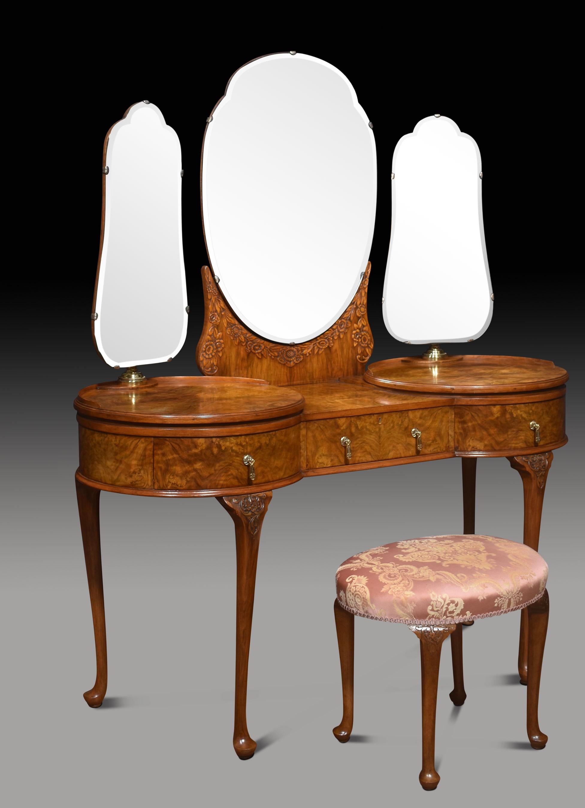 Walnut dressing table. The large central circular bevelled mirror is raised on a carved superstructure. Flanked by unusual side mirrors which have swivel action and can rotate fully. The large shaped walnut top to the freeze is fitted with three