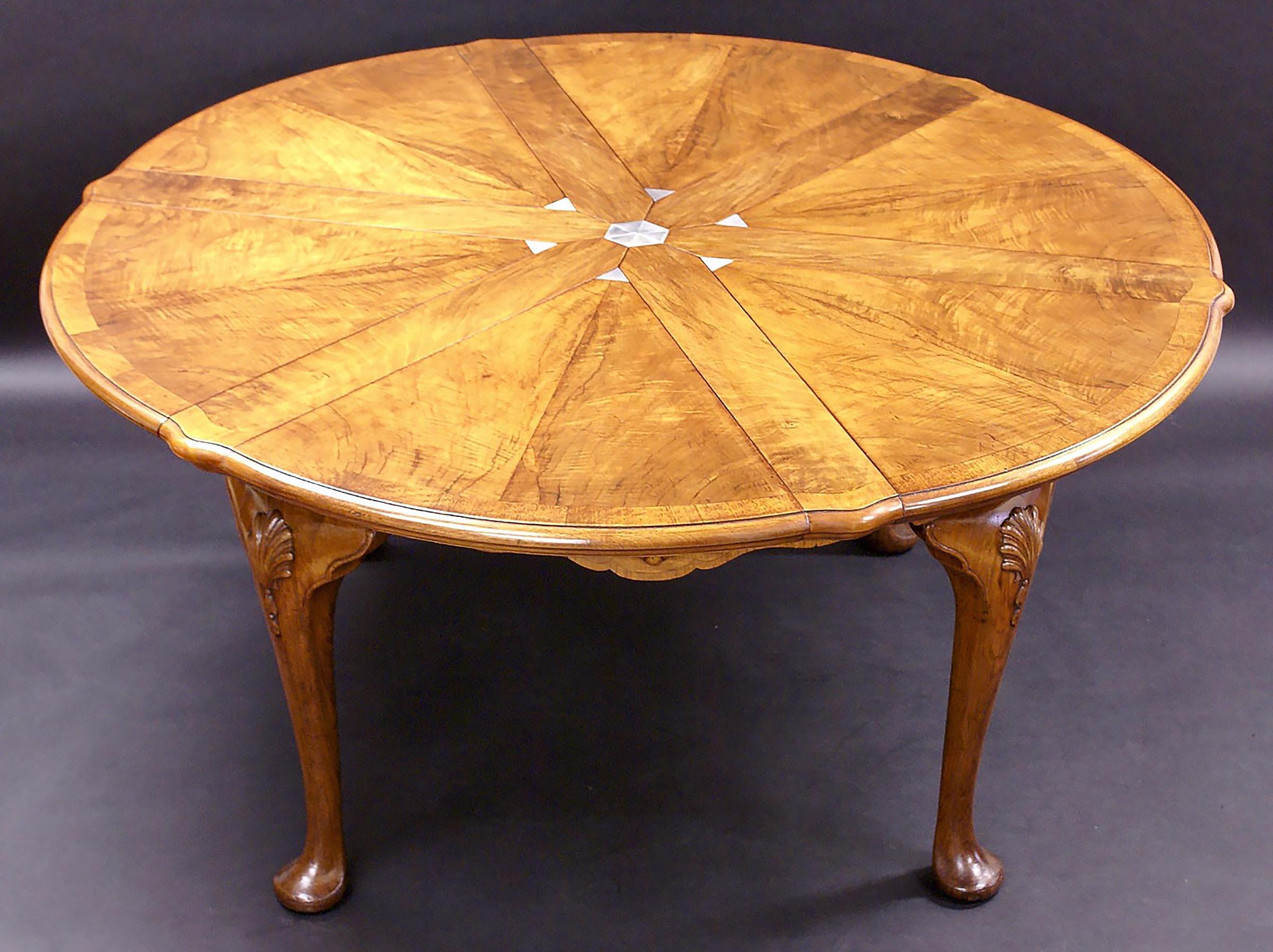 This stunning and very versatile figured walnut circular extending dining table was designed using the mechanism first patented by Robert Jupe in the 19th century. The table has two sets of leaves allowing it to be used in three different sizes. In