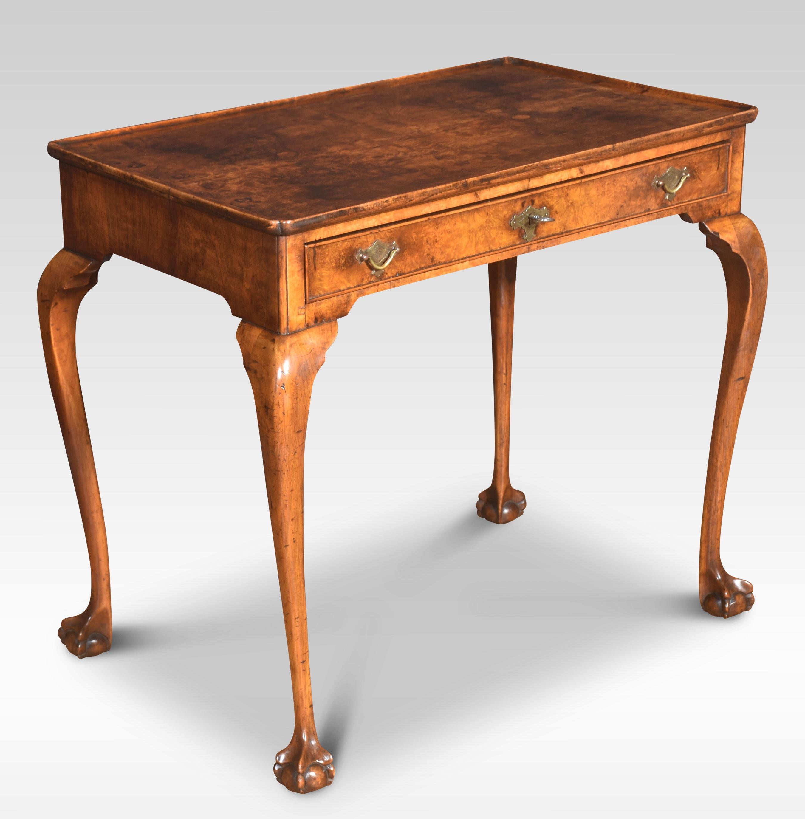 Figured walnut silver table in George I taste, the moulded rectangular top with re-entrant corners, over single frieze drawer with brass handles and engraved escutcheon. All raised up on slender cabriole supports terminating in claws and ball