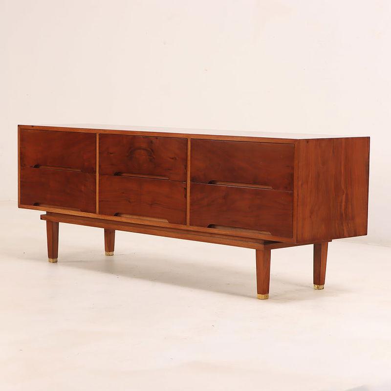 Limpio y sencillo aparador/vestidor de nogal moderno de mediados de siglo, con impresionantes vetas de madera. Esta pieza tiene un gran impacto, desde sus largas patas cónicas con tapas de latón hasta el amplio espacio de almacenamiento que ofrecen