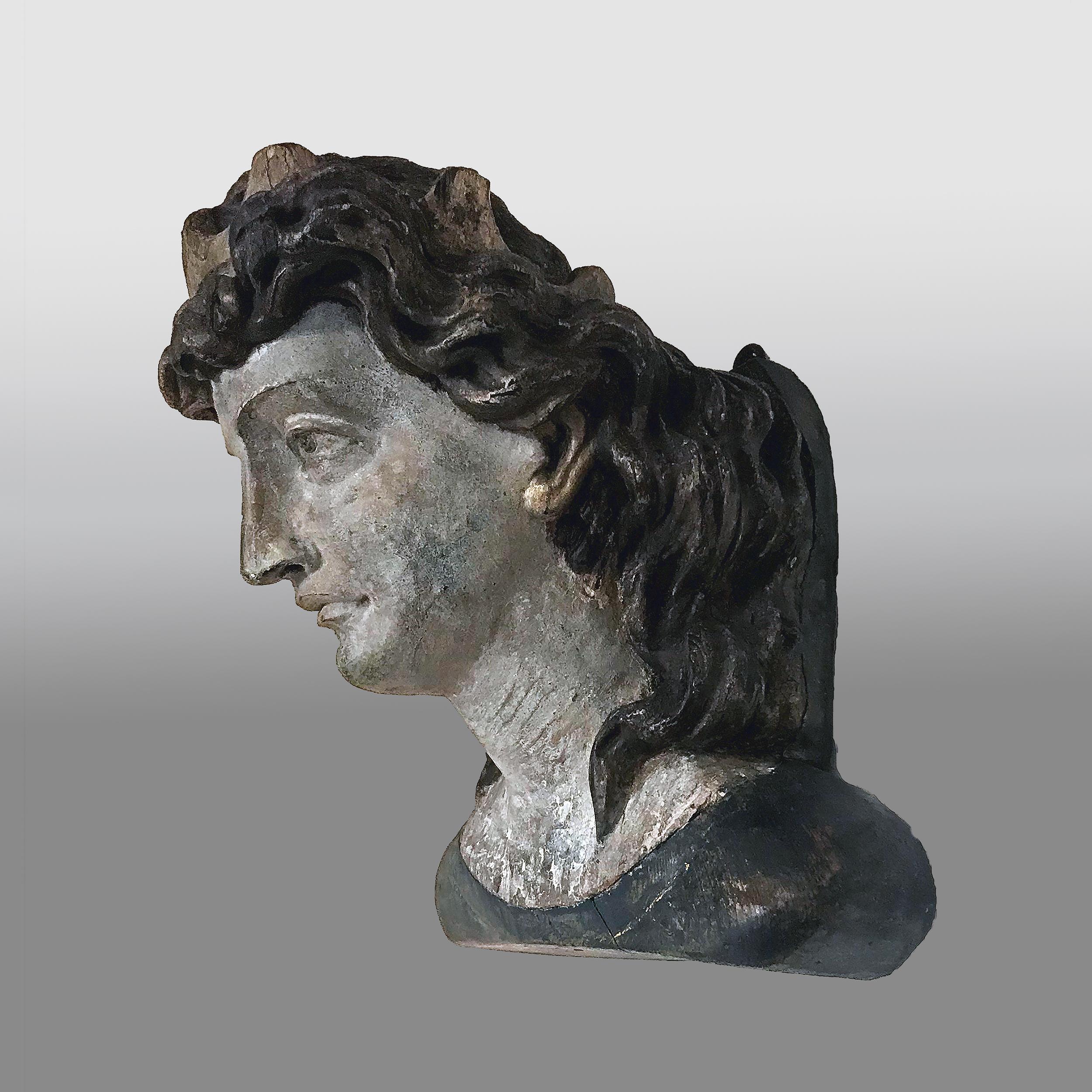 Carved and painted ship's figurehead fragment of a neoclassical woman.
Finely carved with dark hair and a golden diadem.
        