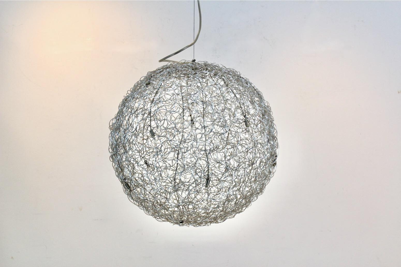 The beautiful sculptural ‘Fil de Fer’ hanging lamp is designed by Catellani & Smith. Fil de Fer is a lighting fixture made of shaped, woven aluminum wire, which is lit by tiny bulbs. Designed and made by Enzo Catellani, it is a creation close to his