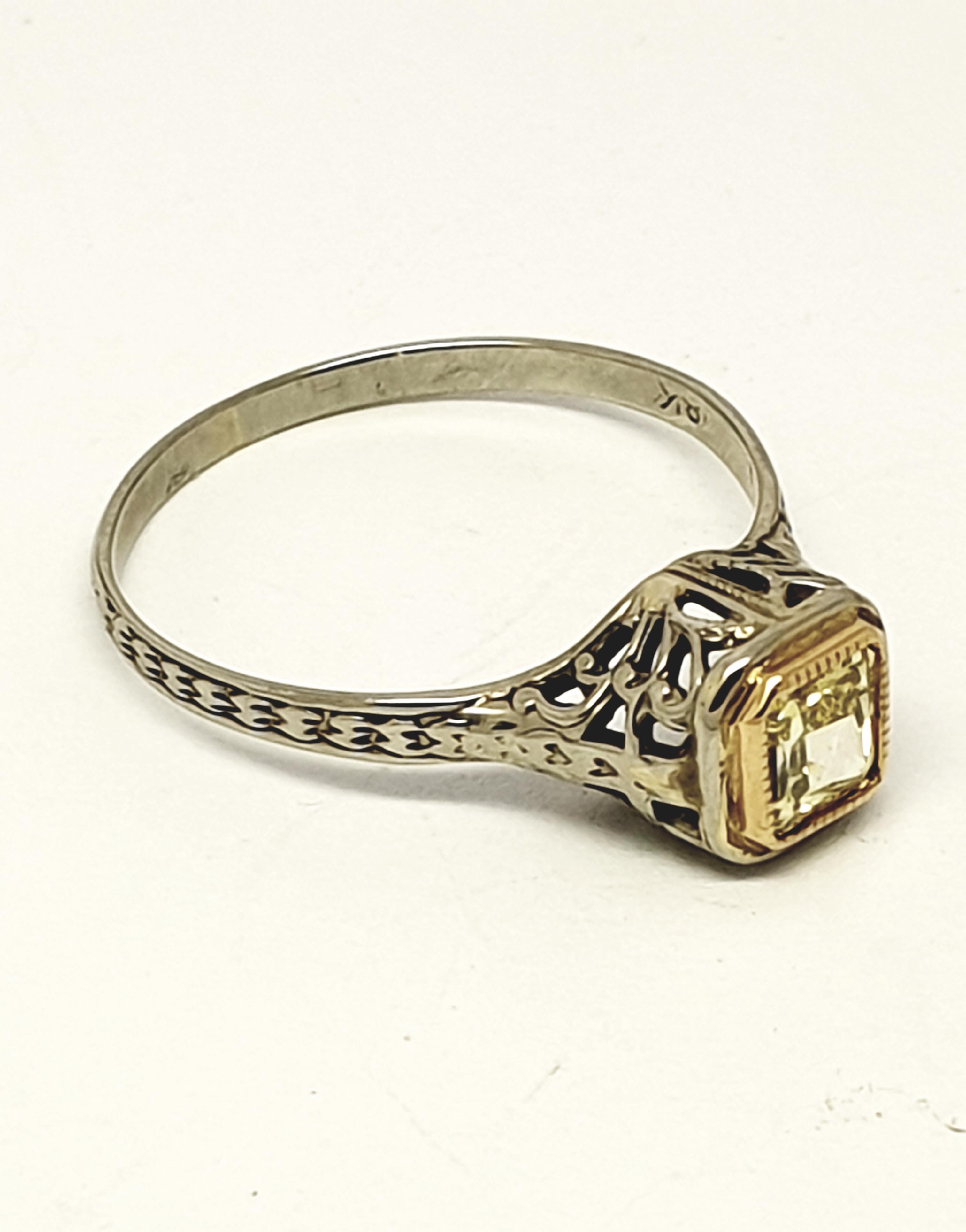 Offering for sale a 0.30 carat princess cut yellow diamond ring. Set in a 14 kt white gold filigree style shank.The diamond is  surrounded with yellow gold design. Very pretty.