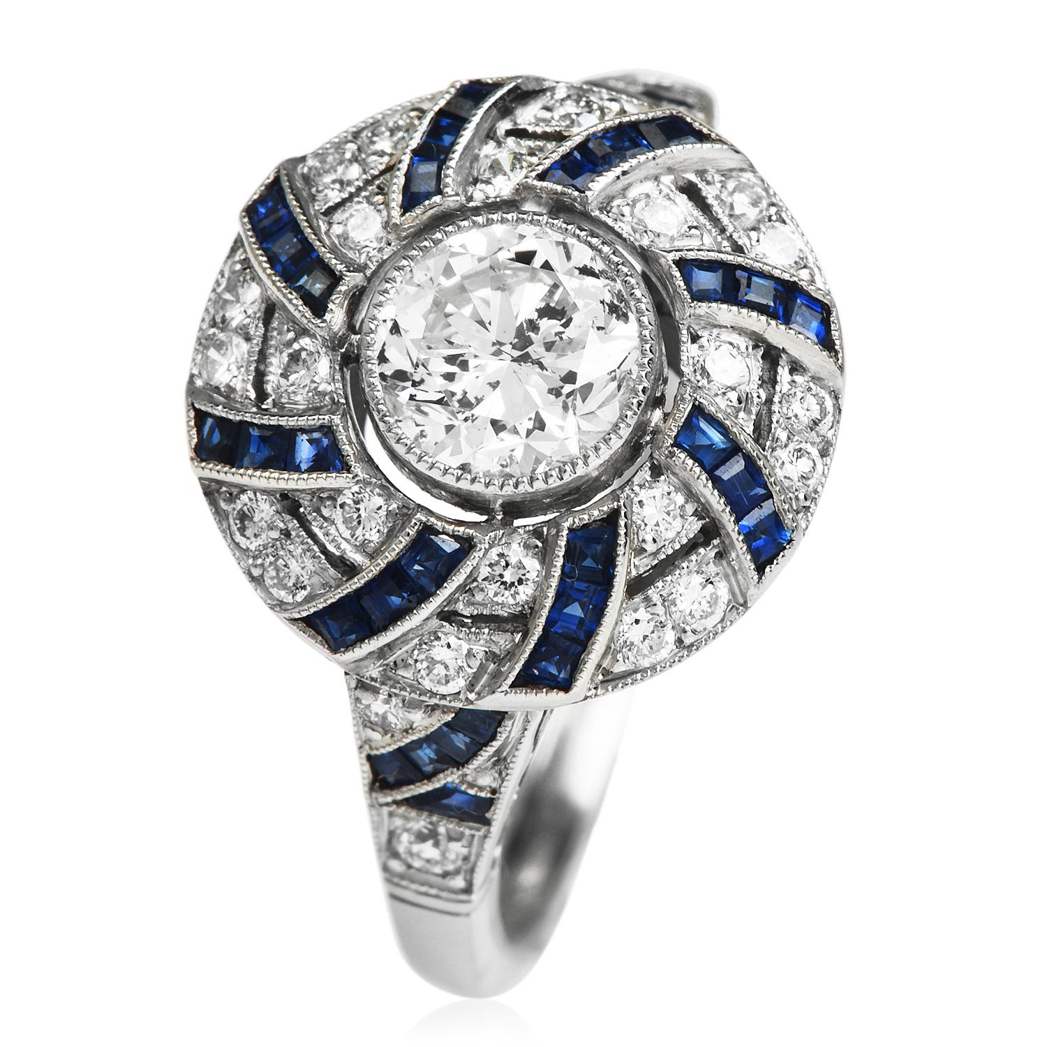 This art deco design, Diamond and Sapphire Ring, is crafted in Platinum.

Featuring a round-cut Round diamond in the center, this ring alternates

Round bezel set diamonds and channel set calibrated cut Sapphire to form an outer ring.

Center
