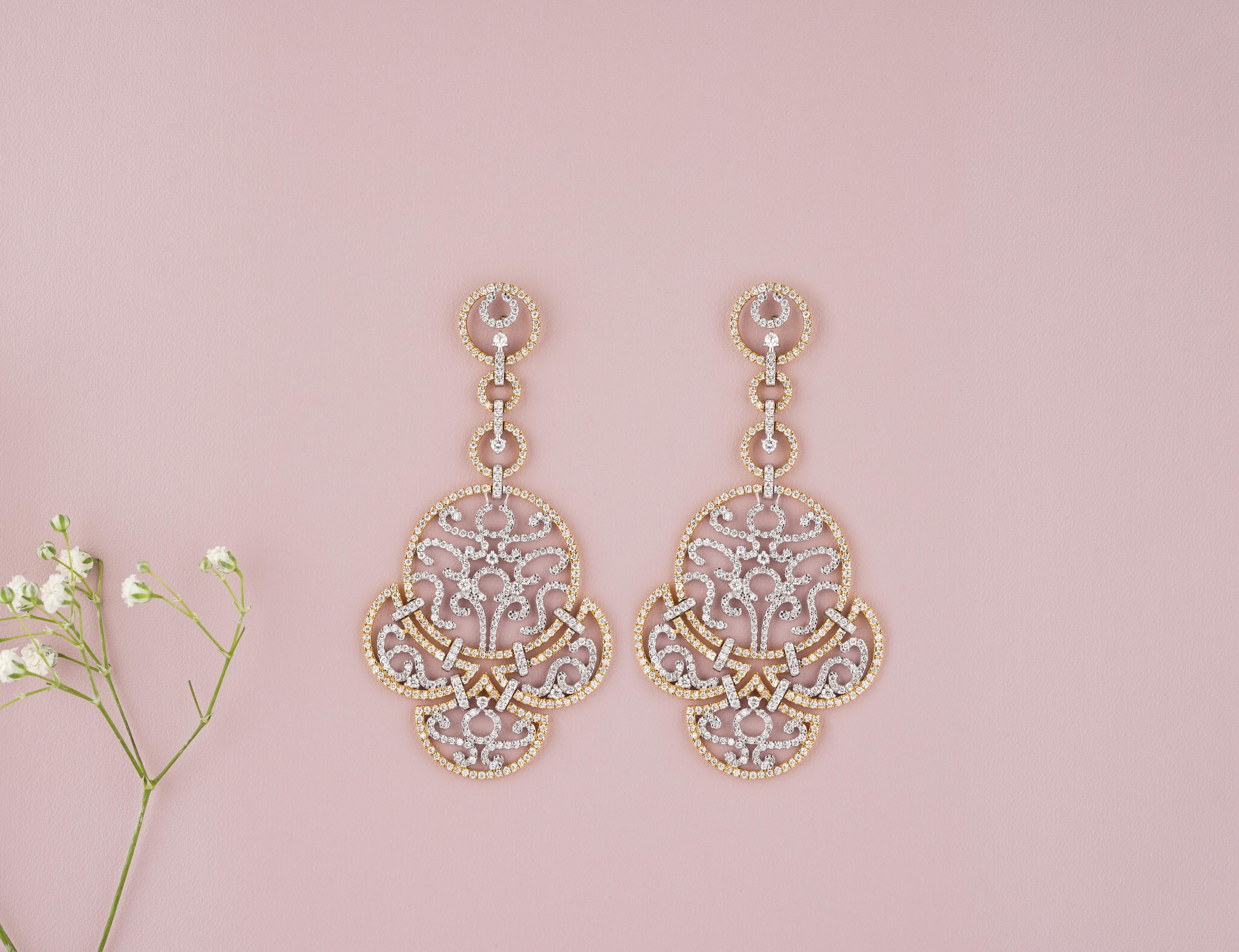 These exquisite earrings feature a filigree design crafted from 18k solid gold, delicately showcasing intricate patterns. Each earring is adorned with a sparkling diamond that dangles gracefully, adding an elegant and luxurious touch to the overall