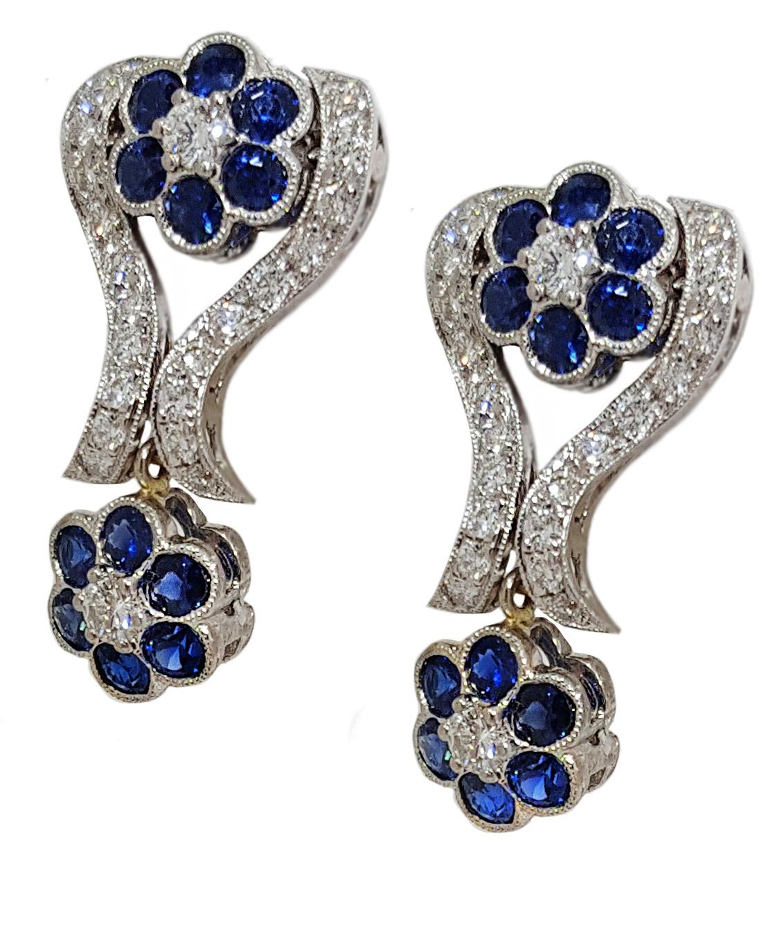 These vintage inspired, romantic, diamond and sapphire earrings contain 1.26ctw of full cut round brilliant diamonds and 2.61ctw of gemmy blue sapphires set in filigree edged and polished 14kt white gold.  Lever clip on back closure.  Earrings