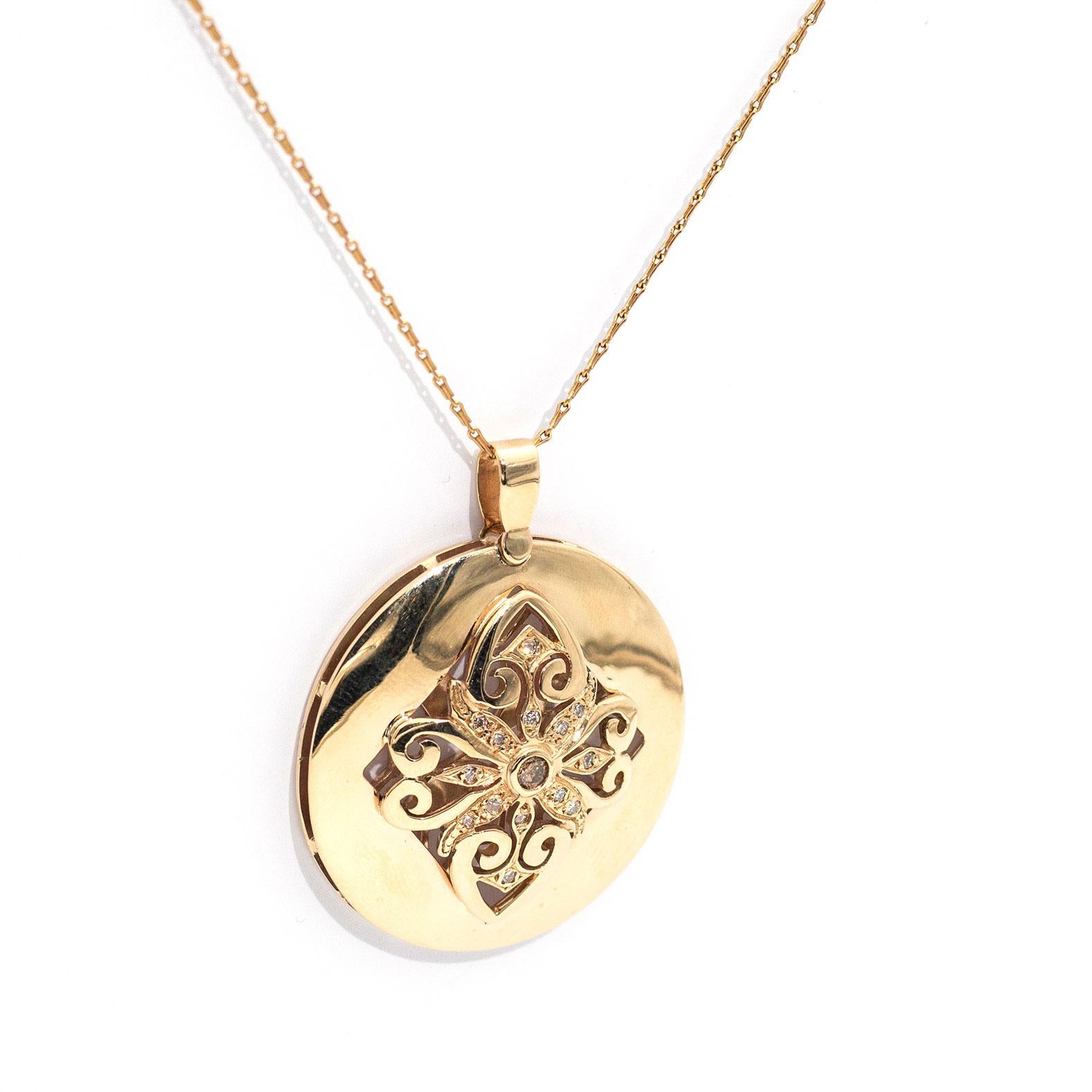 This beautifully unique pendant is forged in 9 cart yellow gold and features a central filigree motif carefully set with a lovely central cognac round brilliant cut diamond and is encompassed by sparkling white round brilliant cut diamonds and