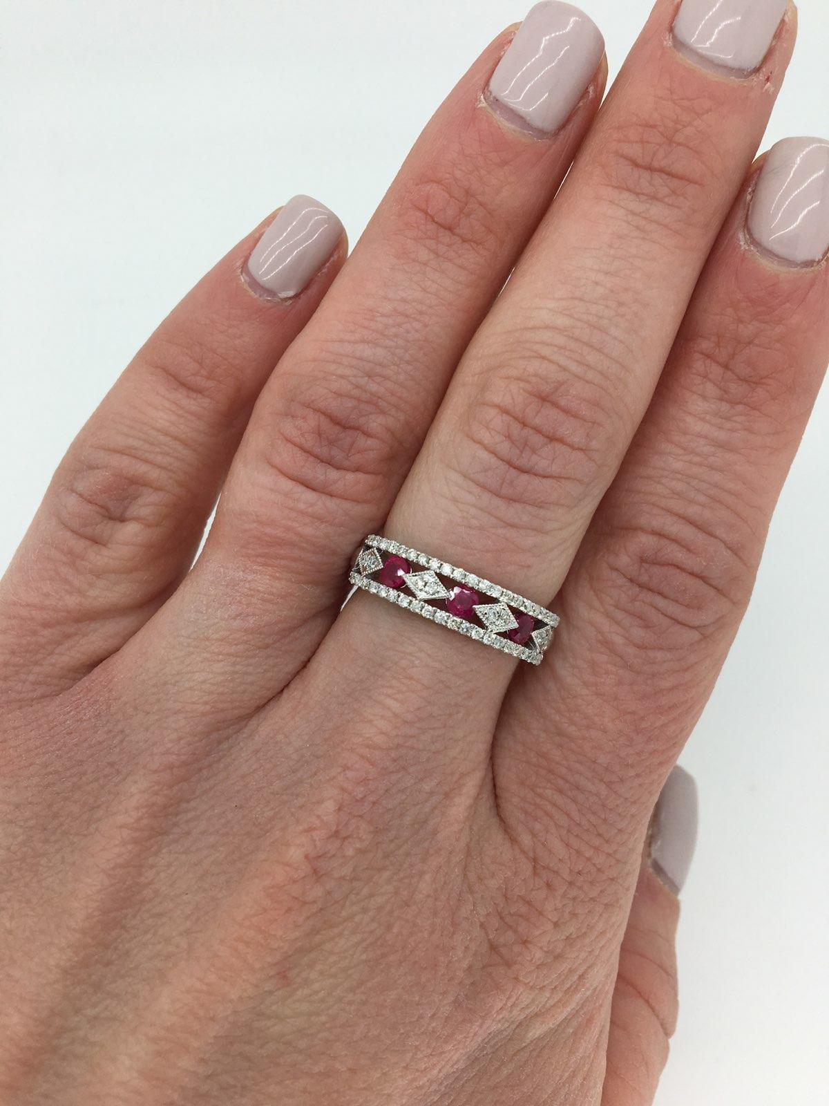 Uniquely designed Ruby and Diamond band crafted in 14K white gold.

Gemstone: Ruby & Diamond
Gemstone Carat Weight: Approximately .44CTW Round Cut Rubies
Diamond Carat Weight:  Approximately .32CTW
Diamond Cut: Round Brilliant
Color: Average