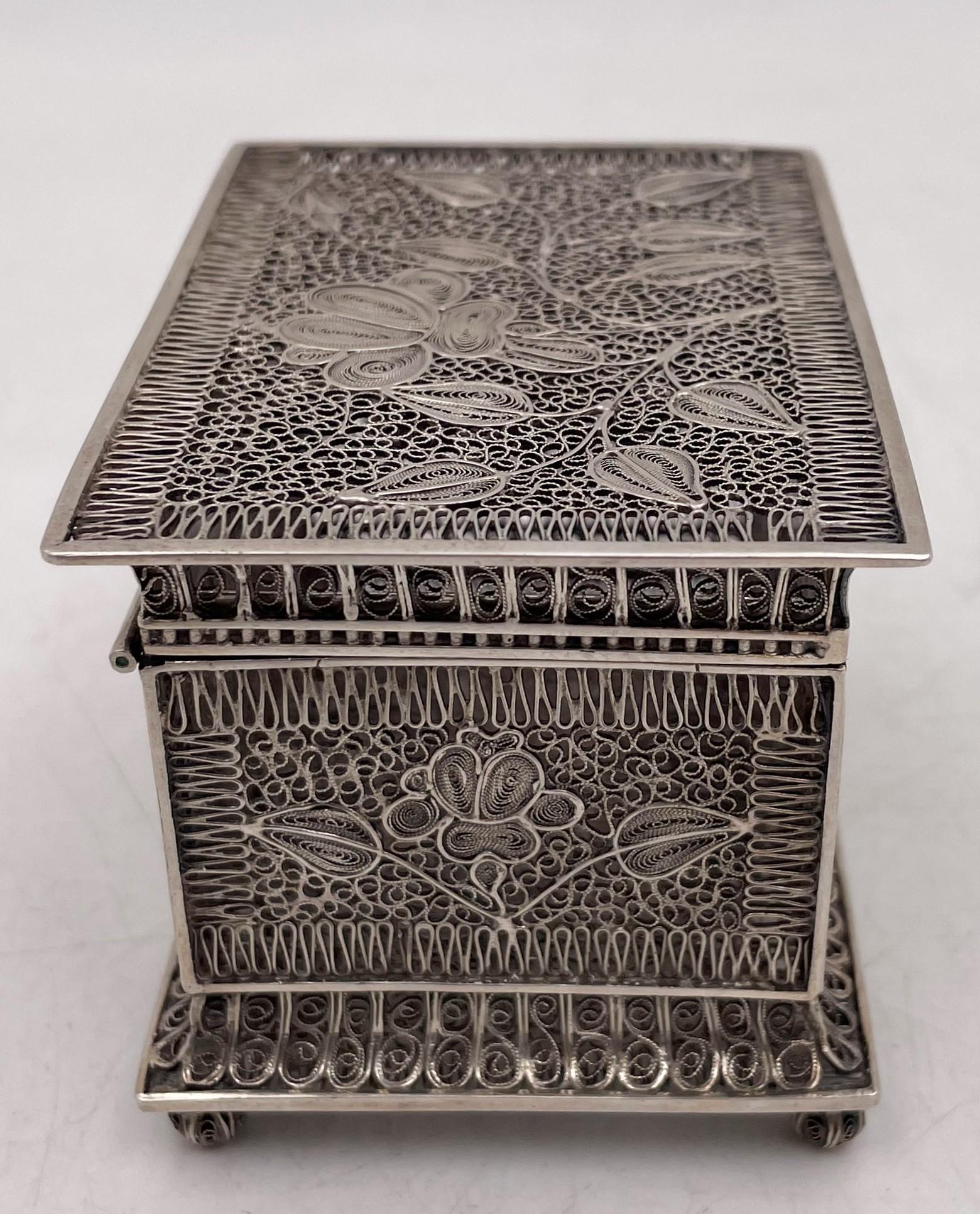 Silver box, in filigree motif, probably Russian or Chinese, showcasing intricate floral and geometric designs, from the early 20th century, measuring 3 1/4'' in length by 2 1/4'' in width by 2 1/4'' in height. 

Please feel free to ask us any