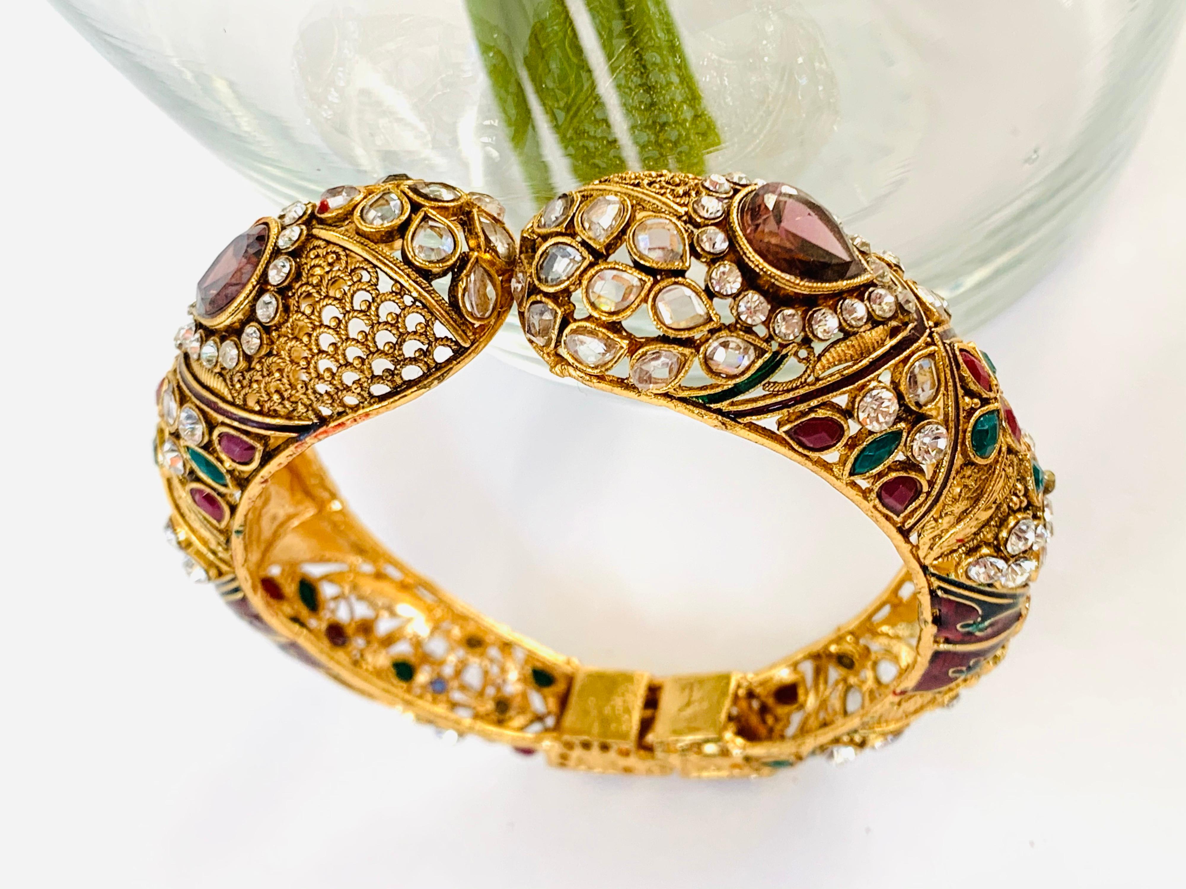 This intricate bangle bracelet is embellished with faux tourmaline, the hand finished filigree gold pattern is enhanced with green and red enamel.  It's is an openable bangle.  Inner diameter 65.00 mm (2.56 in)

FOLLOW  MEGHNA JEWELS storefront to