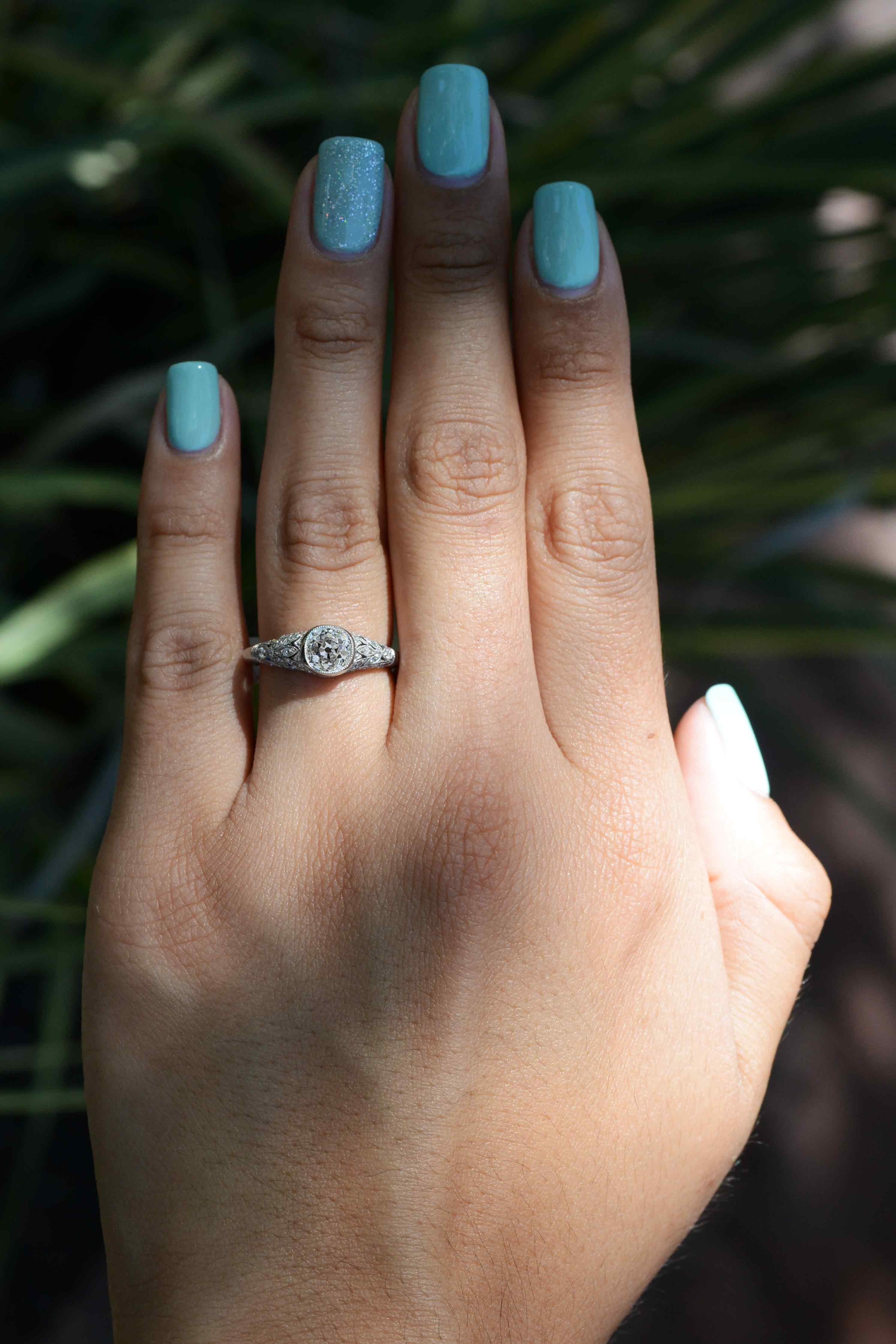 Dieser antike edwardianische Ring wurde mit einem wunderschönen 1-Karat-Diamanten aus alter Mine restauriert, der in einer Milgrain-Lünette gehalten wird. Handgravierte Blätter aus Platin, die das Band säumen, zeigen den maßgeschneiderten Stil der