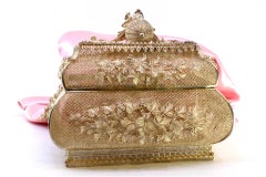 Filigree jewelry box with raised floral details and fruit-shaped lid handle