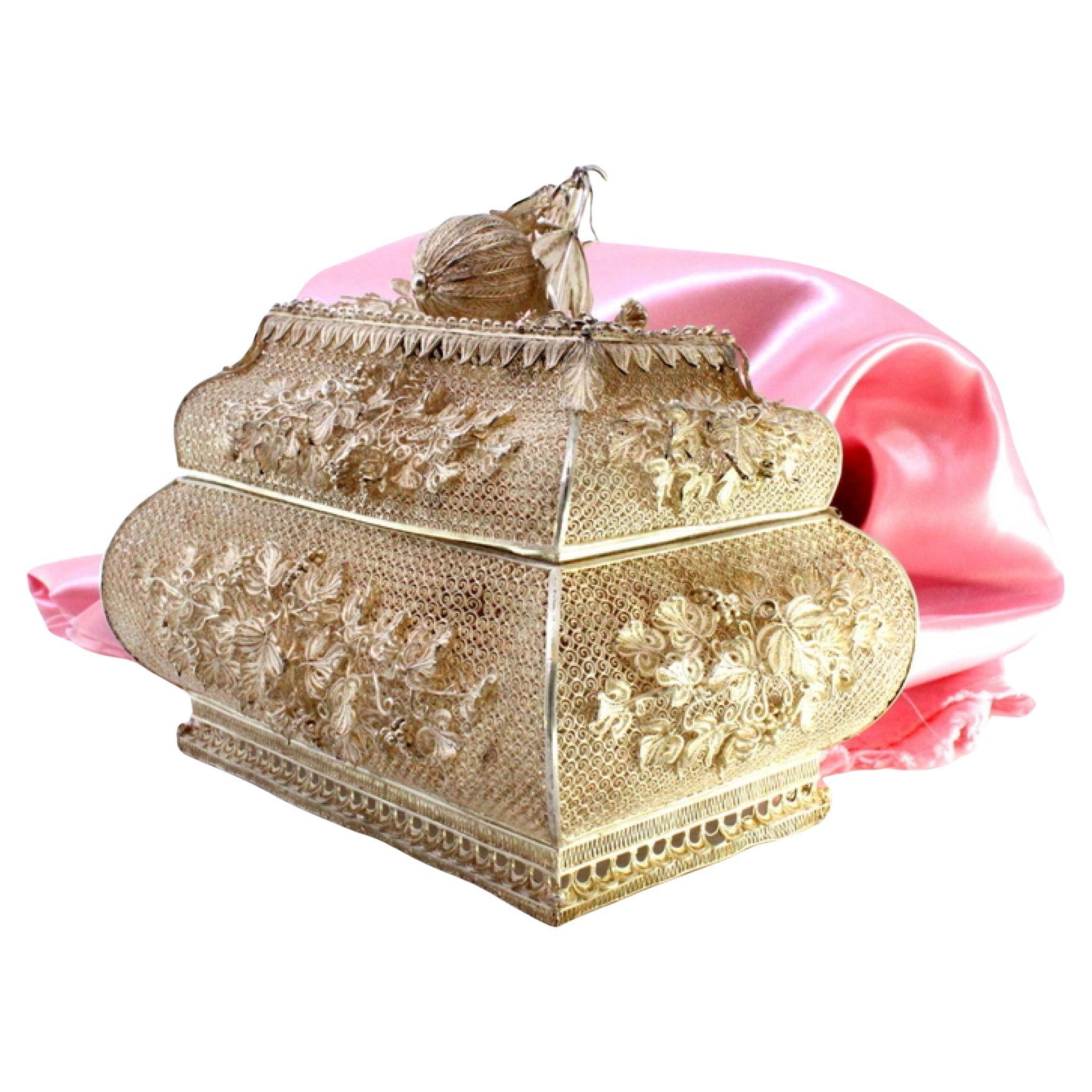Filigree jewelry box with raised floral details and fruit-shaped lid handle