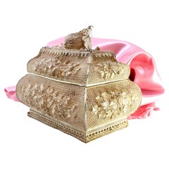 Filigree jewelry box with raised floral details and fruit-shaped lid handle