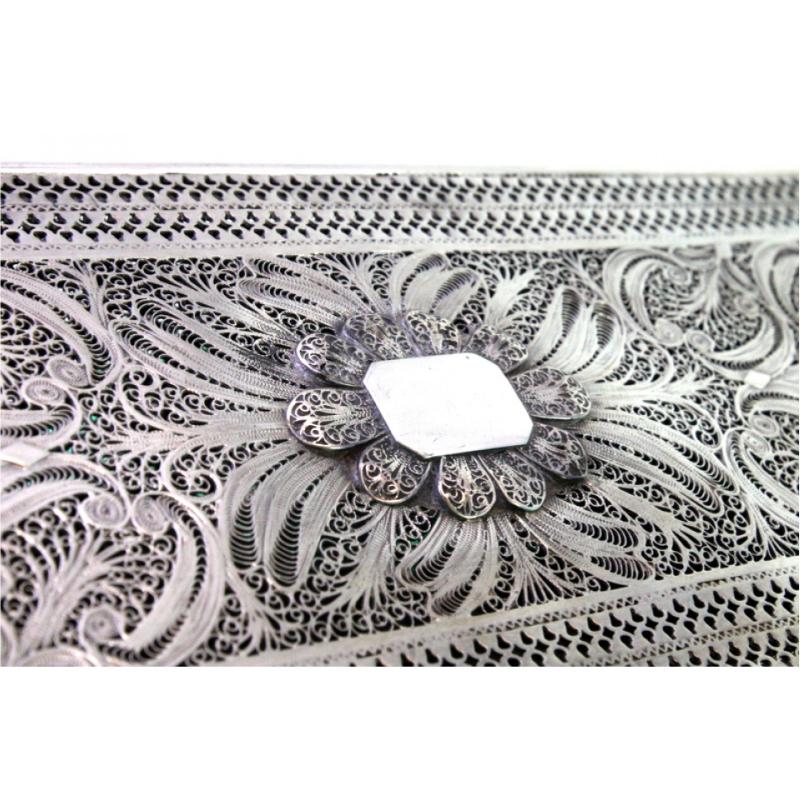 Description: Filigree silver box with applications and monogram plaque on the lid, resting on four round feet. Metal: Silver. Origin: Middle East. Hallmark: Absent. Weight: 356.09 grams. Dimensions: 8.1cmx20.6cm. Content: 833/1000. Assay Mark: