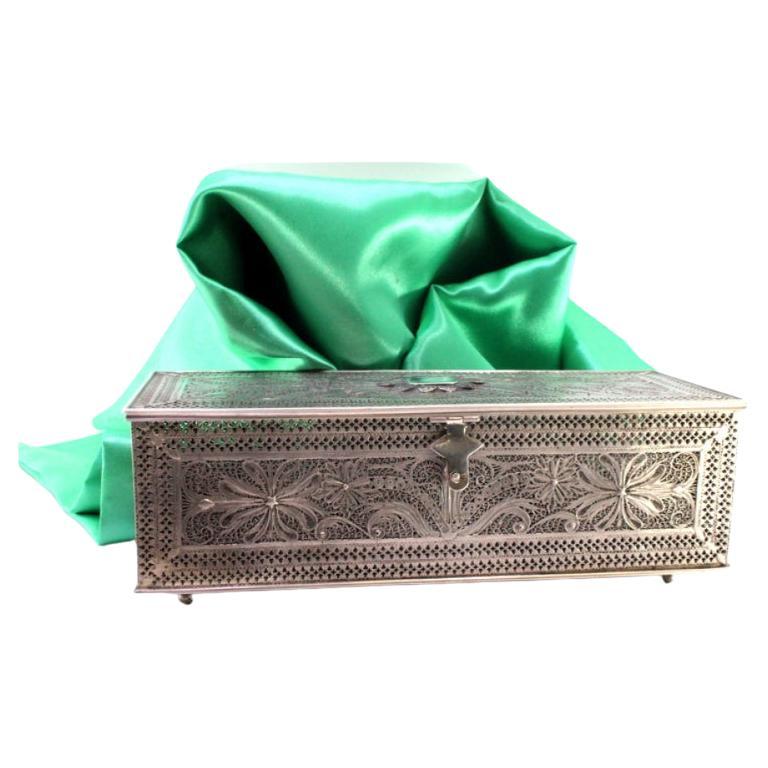 Filigree silver box with applications, monogram lid and four round feet