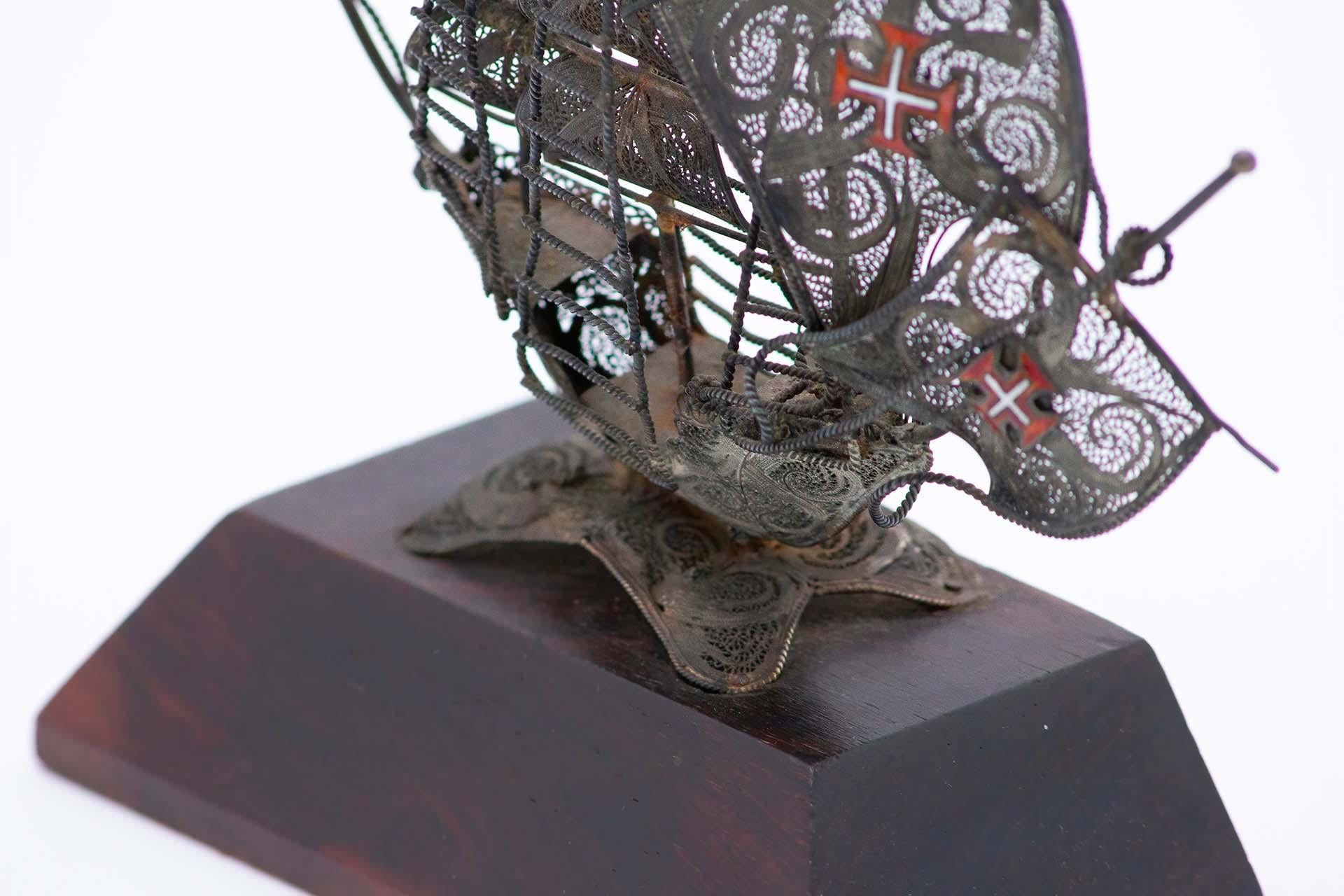 Descrizione: Caravella in filigrana d'argento con base in legno. Metallo: Argento. Origine: Portoghese. Marchio: aquila in piedi. Peso: 366,05 grammi. Dimensioni: 18,5 cm x 19,2 cm. Contenuto: 833/1000. Marchio di controllo: Sì, tra il 1938 e il