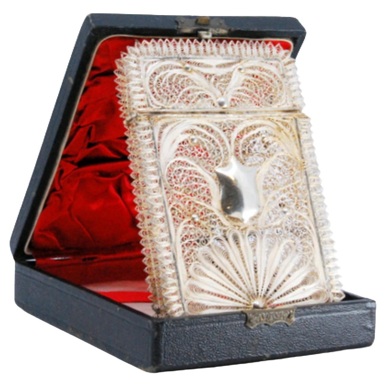 Filigree silver card case with a central monogram card and hinged lid