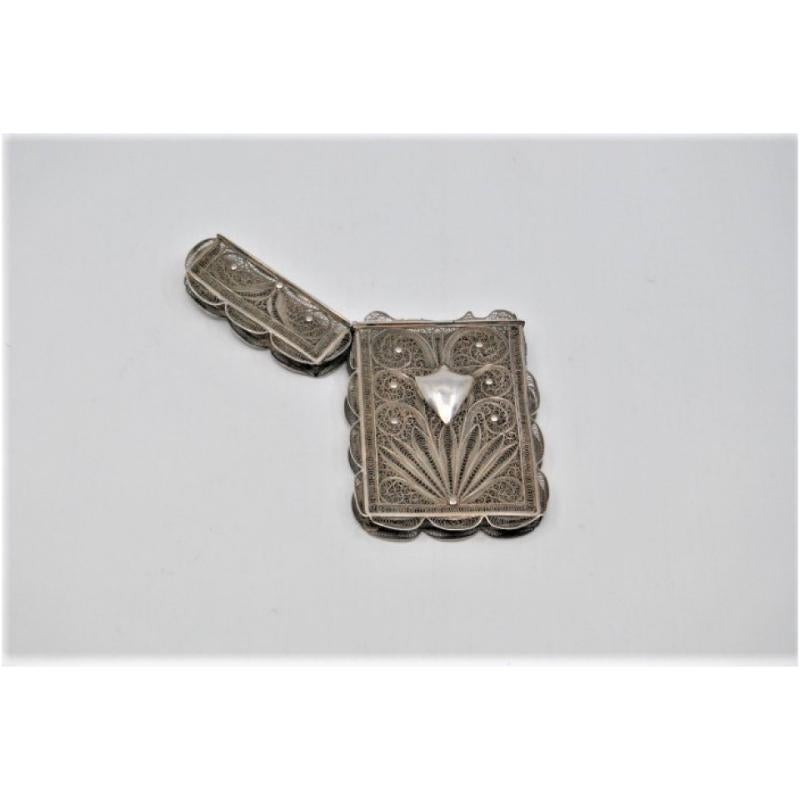 Descrizione: Cartoniera in argento filigranato con coperchio rimovibile. Metallo: Argento. Origine: Portoghese. Marchio: Auaente. Peso: 44,10 grammi. Dimensioni: 10x6cm. Contenuto: 833/1000. Segno del saggio: Assente. Informazioni aggiuntive: Buone