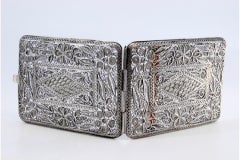 Filigree silver cigarette case decorated with floral motifs and a hinged lid