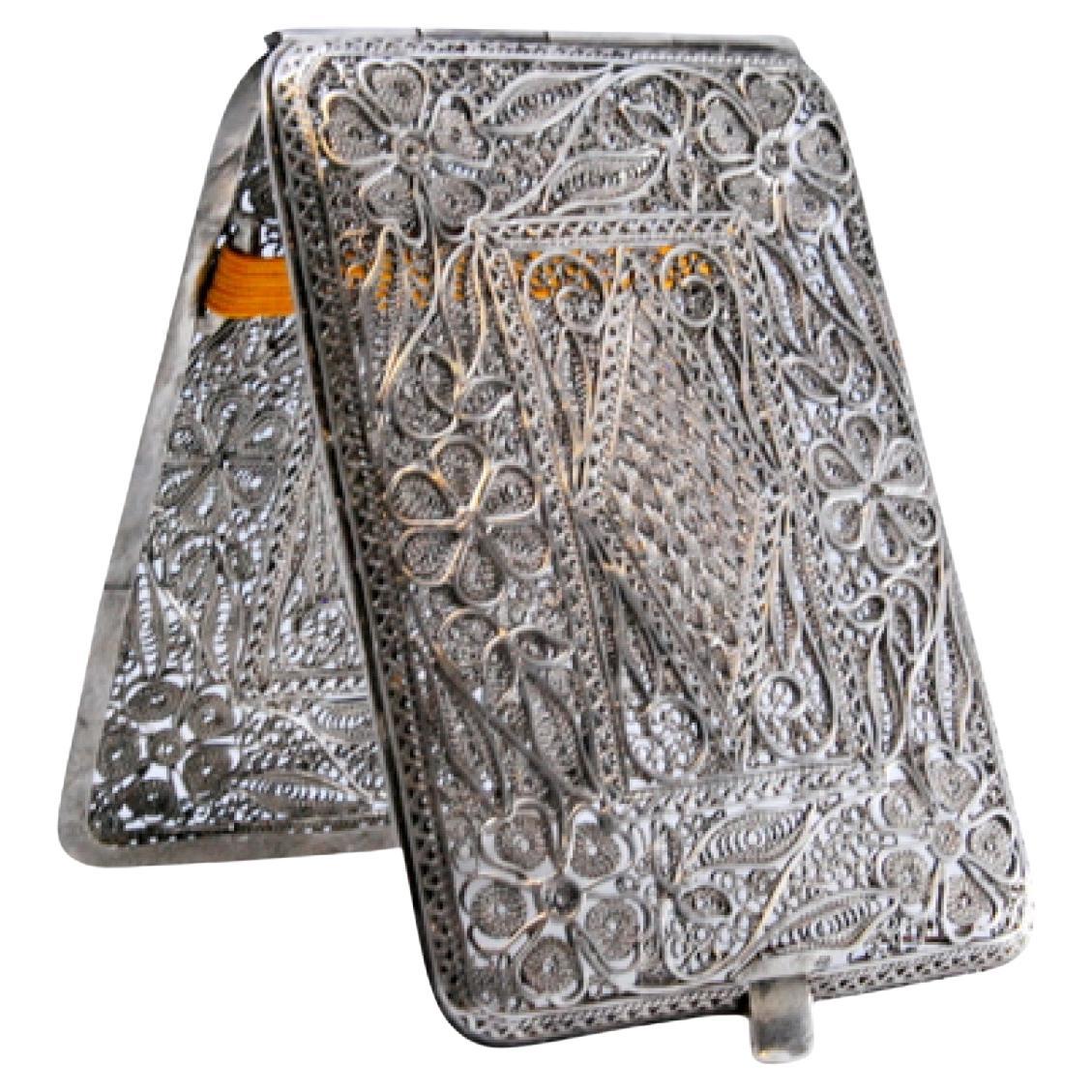 Filigree silver cigarette case decorated with floral motifs and a hinged lid