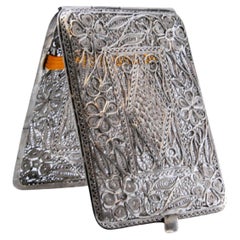 Filigree silver cigarette case decorated with floral motifs and a hinged lid