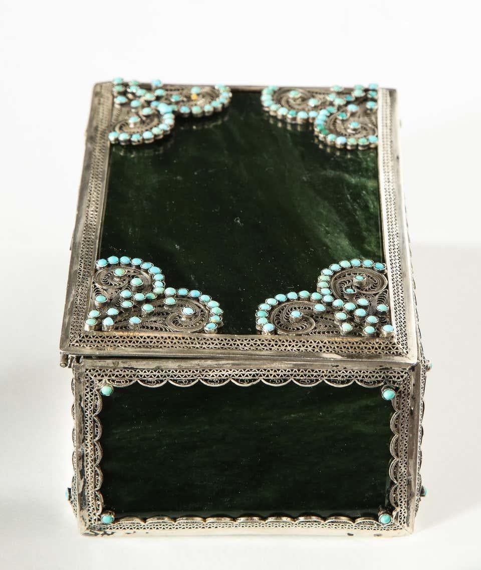 A filigree sterling silver-mounted nephrite and turquoise rectangular table box, circa 1900.  

Beautiful looking box. Great quality, and very decorative. 

Mounted with Nephrite panels, and turquoise beads.   

Good condition.  

Measures: 2.5