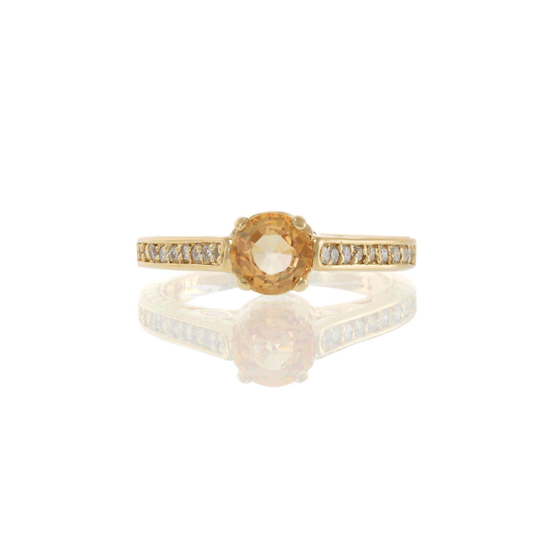 Questo anello in oro giallo 14KT mette in mostra un caldo zaffiro giallo di 0,92 carati a taglio rotondo al centro, accentuato da 0,30 carati di diamanti rotondi a taglio brillante lungo le spalle e nella galleria in filigrana. L'intricato traforo