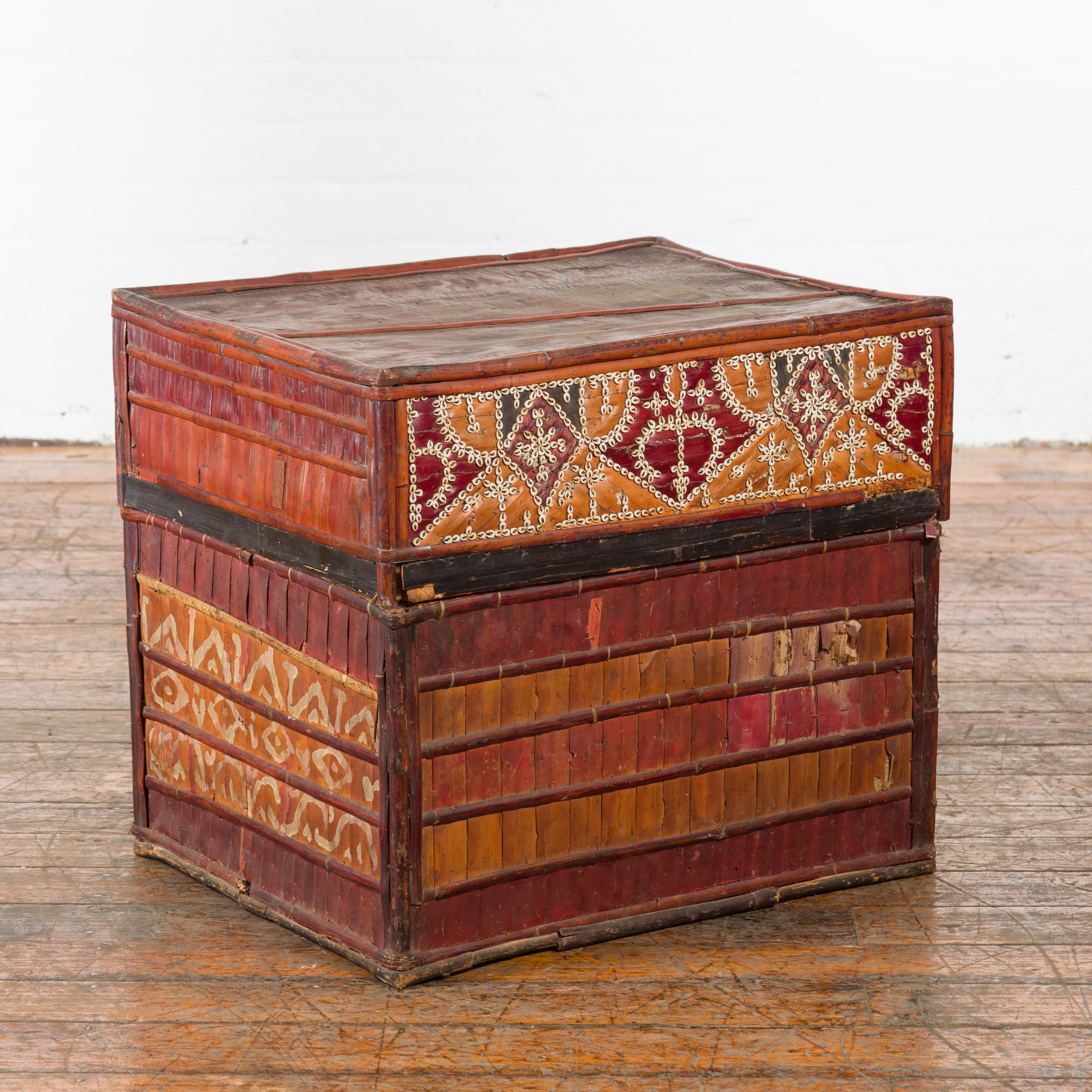 A Filipino tobacco leaf grain basket from the mid 20th century, with polychrome décor. Created in the Philippines during the midcentury period, this tobacco leaf grain basket features a rectangular lid adorned with a charming polychrome décor in the