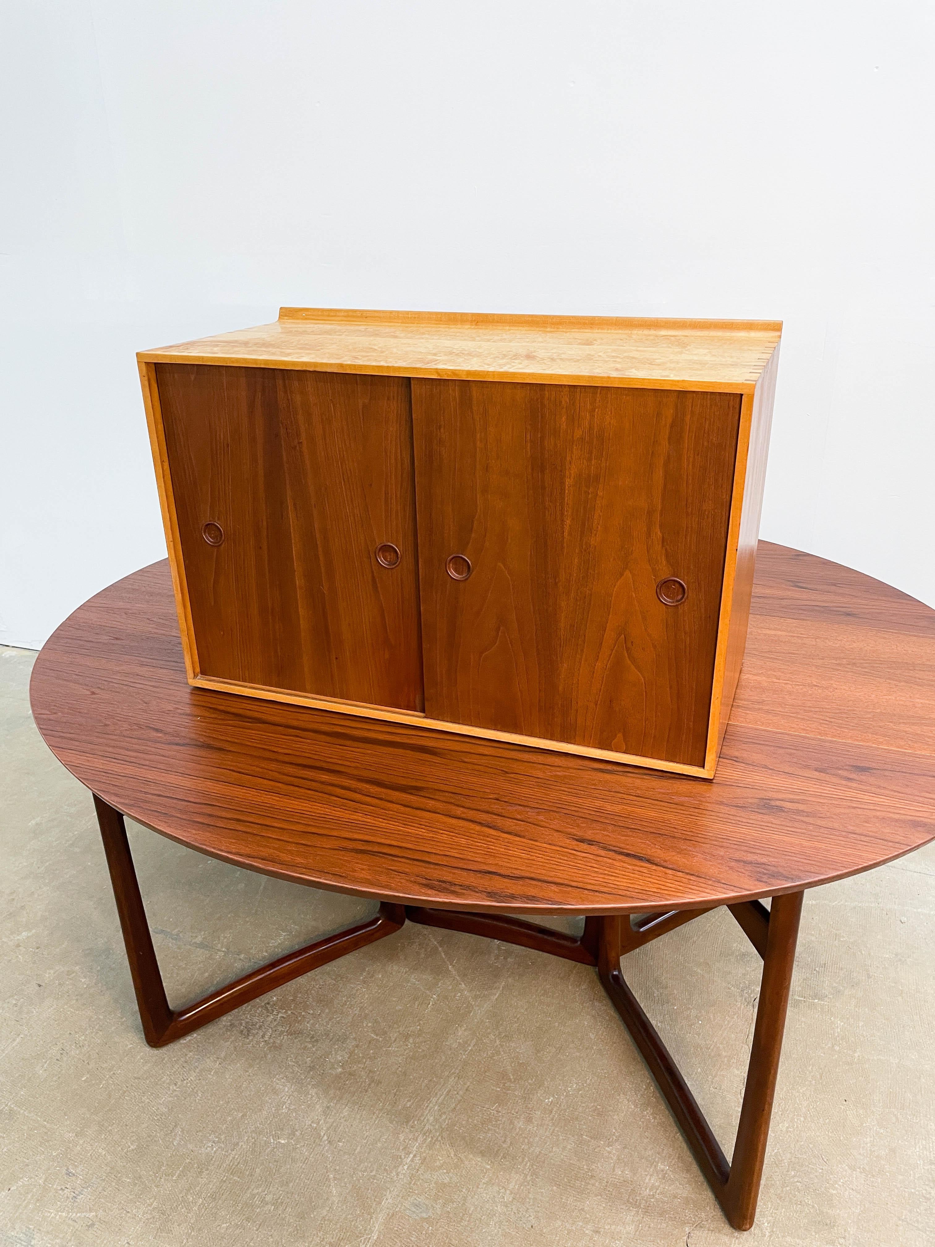 This is a stunning piece of Danish Modern design by the master Finn Juhl. Made in the early 1950s by Baker Furniture, this maple case wall-hung cabinet has distinctive walnut sliding doors and moveable interior shelves.

The cabinet comes with two