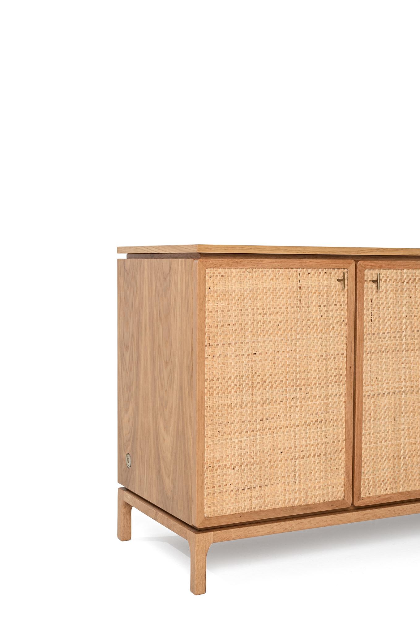 Fillet is a console table that takes its name from its corner details and emphasizes functionality and practicality. It is complemented by the natural wicker material on its covers, which harmonizes with the overall oak texture. Its interior
