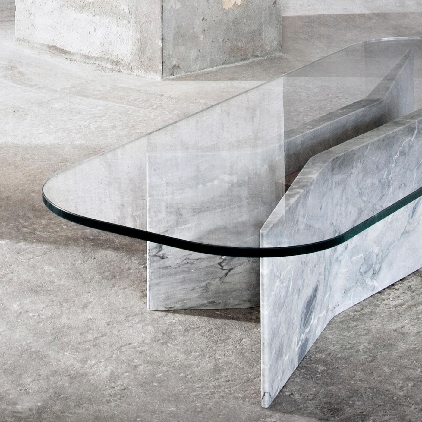 Topped by an extra-clear glass top (1.5cm thick) with rounded corners, this sophisticated coffee table features a sturdy base combining two sculpted slabs in prized Versilys marble distinguished by an effortless sculptural effect. This exclusive