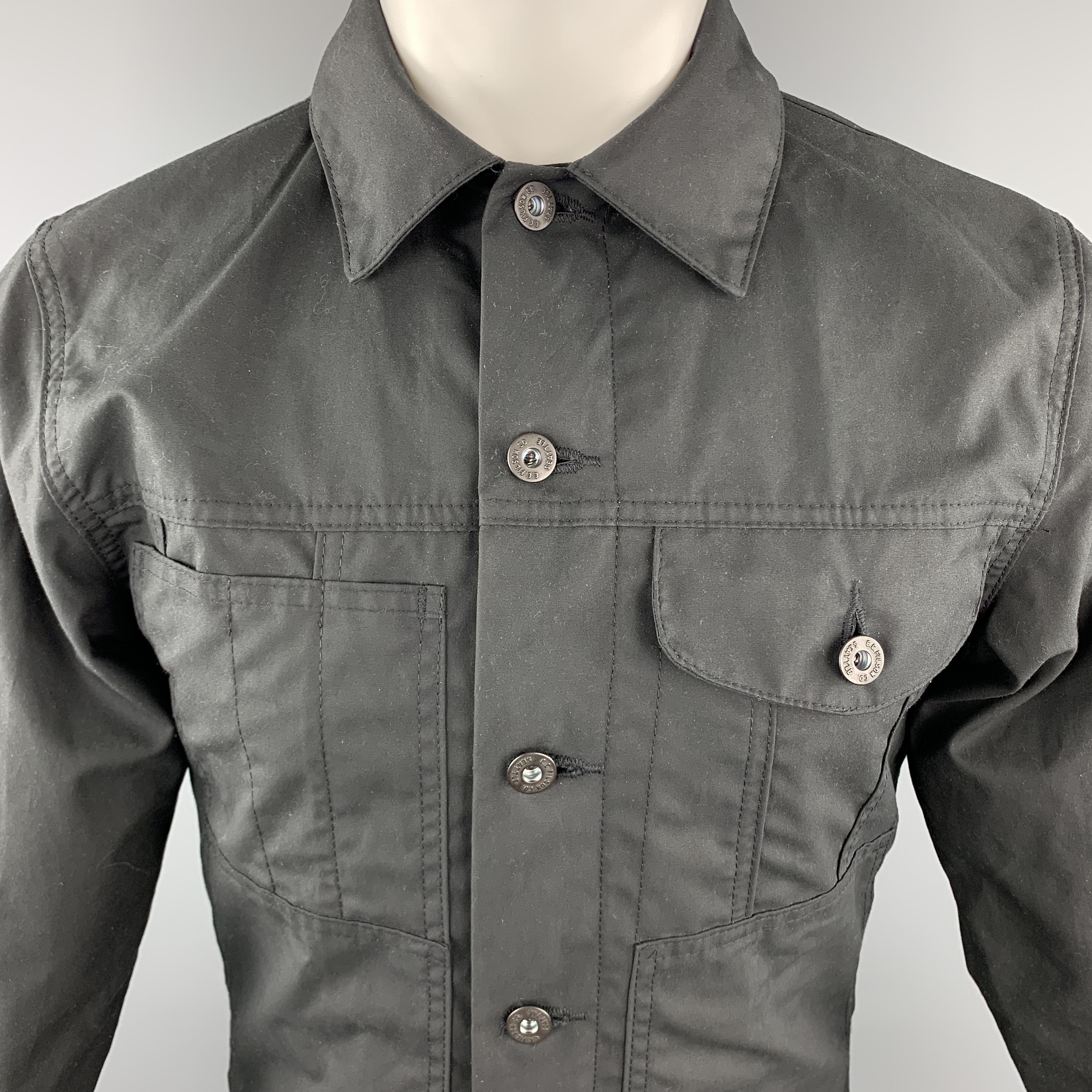 FILSON Trucker Jacket comes in a black tone in a solid coated cotton material, with patch pockets, buttoned cuffs, lined, button up. Made in USA. 

Excellent Pre-Owned Condition.
Marked: XS

Measurements:

Shoulder: 16.5 in. 
Chest: 38 in. 
Sleeve: